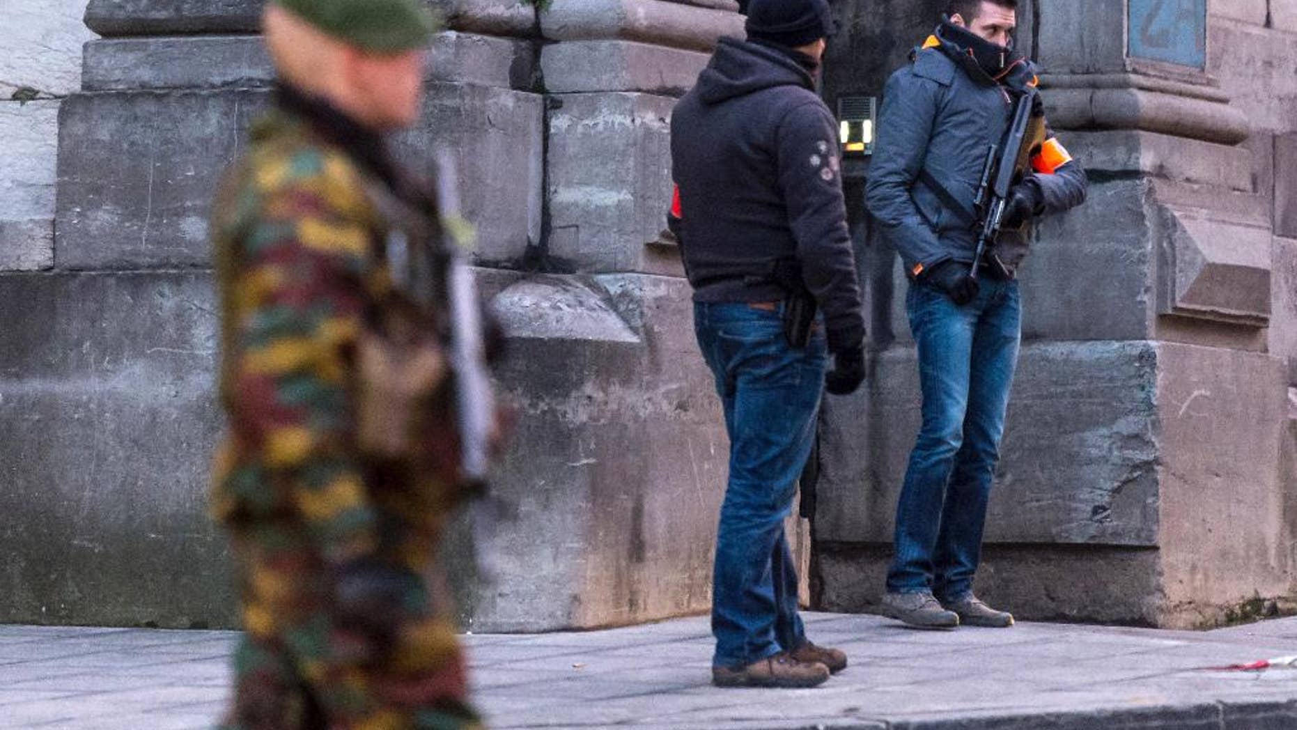 FILE - In this Wednesday, Jan. 21, 2015 file photo, a Belgian para-commando and anti-terror squad policemen guard the parking area at the Palace of Justice, where suspects wanted in Belgium on terrorism-related charges have to appear before the federal court in Brussels. On Monday June 8, 2015 Belgian police arrested 16 people in twin terrorism-related investigations involving Chechen extremists, authorities said. Members of one group, based in western Flanders, were allegedly active in Syria and probably participated in combat there, prosecutors said. (AP Photo/Geert Vanden Wijngaert, File)