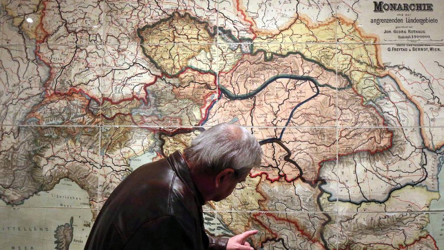 ADVANCE FOR SUNDAY JUNE 15 2014 TO GO WITH STORY WWI-THE GREAT WAR -In this Tuesday, April 1, 2014 photo, a visitor looks at a school wall map of the Austrian-Hungarian Empire from 1900 that was corrected with new borders after World War I at a special exhibition on World War I at the Schallaburg castle, in Austria. (AP Photo/Ronald Zak)
