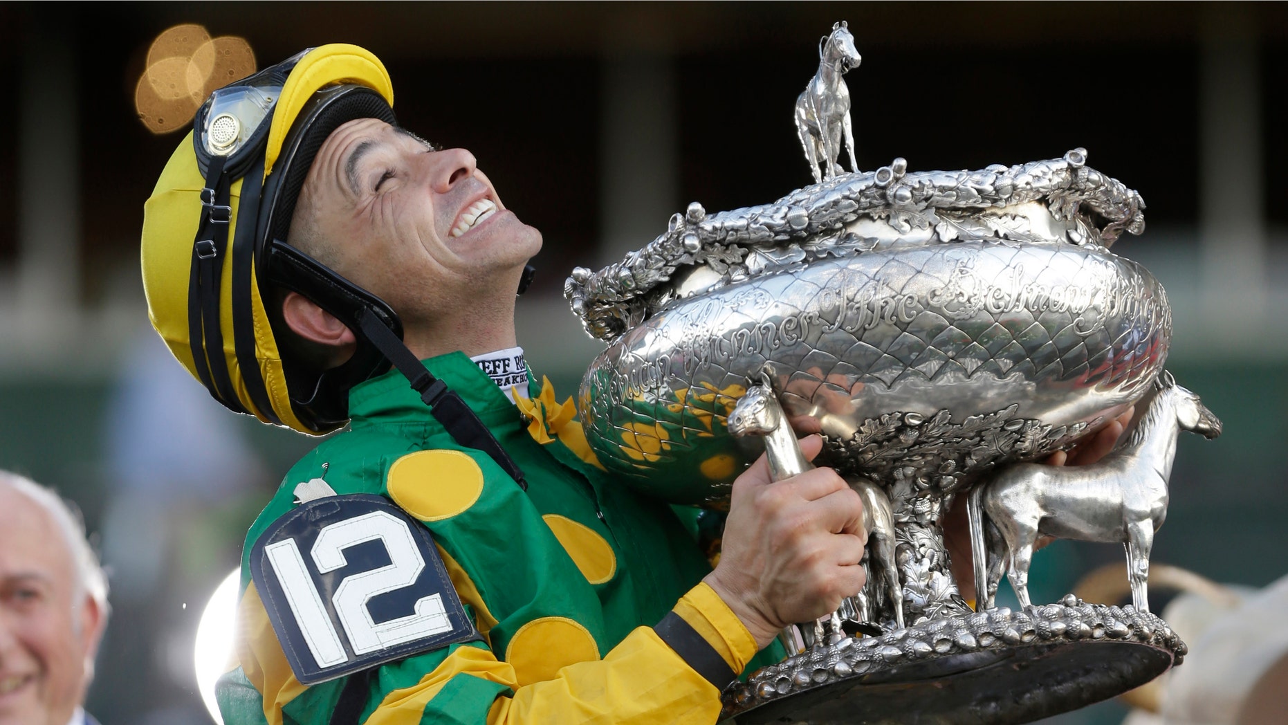 Jockey Mike Smith holds the Belmont Stakes trophy in the winner's circle after riding Palace Malice to win the race at Belmont Park in Elmont, N.Y., Saturday, June 8, 2013. (AP Photo/Seth Wenig)