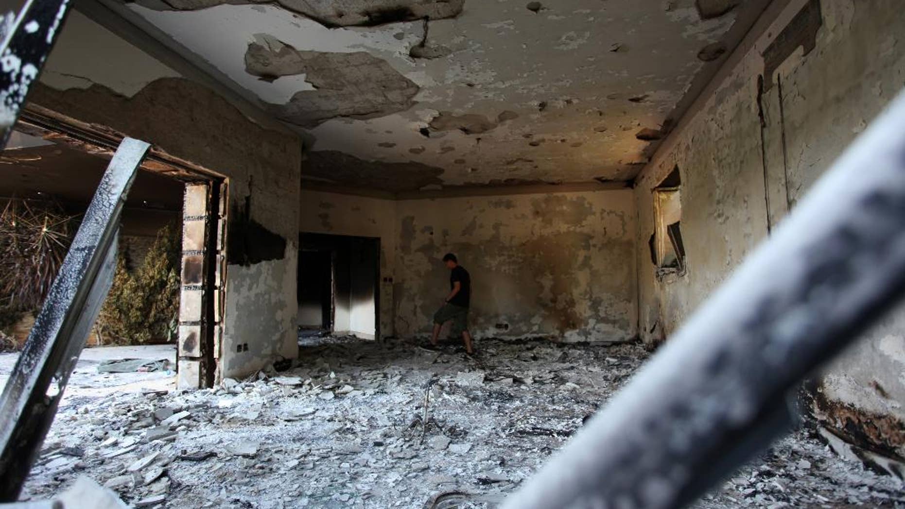 FILE - In this Sept. 13, 2012 file photo, a Libyan man walks in the rubble of the damaged U.S. consulate, after an attack that killed four Americans, including Ambassador Chris Stevens on the night of Tuesday, Sept. 11, 2012, in Benghazi, Libya. A two-year investigation by the Republican-controlled House Intelligence Committee has found that the CIA and the military acted properly in responding to the 2012 attack on a U.S. diplomatic compound in Benghazi, Libya, and asserted no wrongdoing by Obama administration appointees. (AP photo/Mohammad Hannon, File)