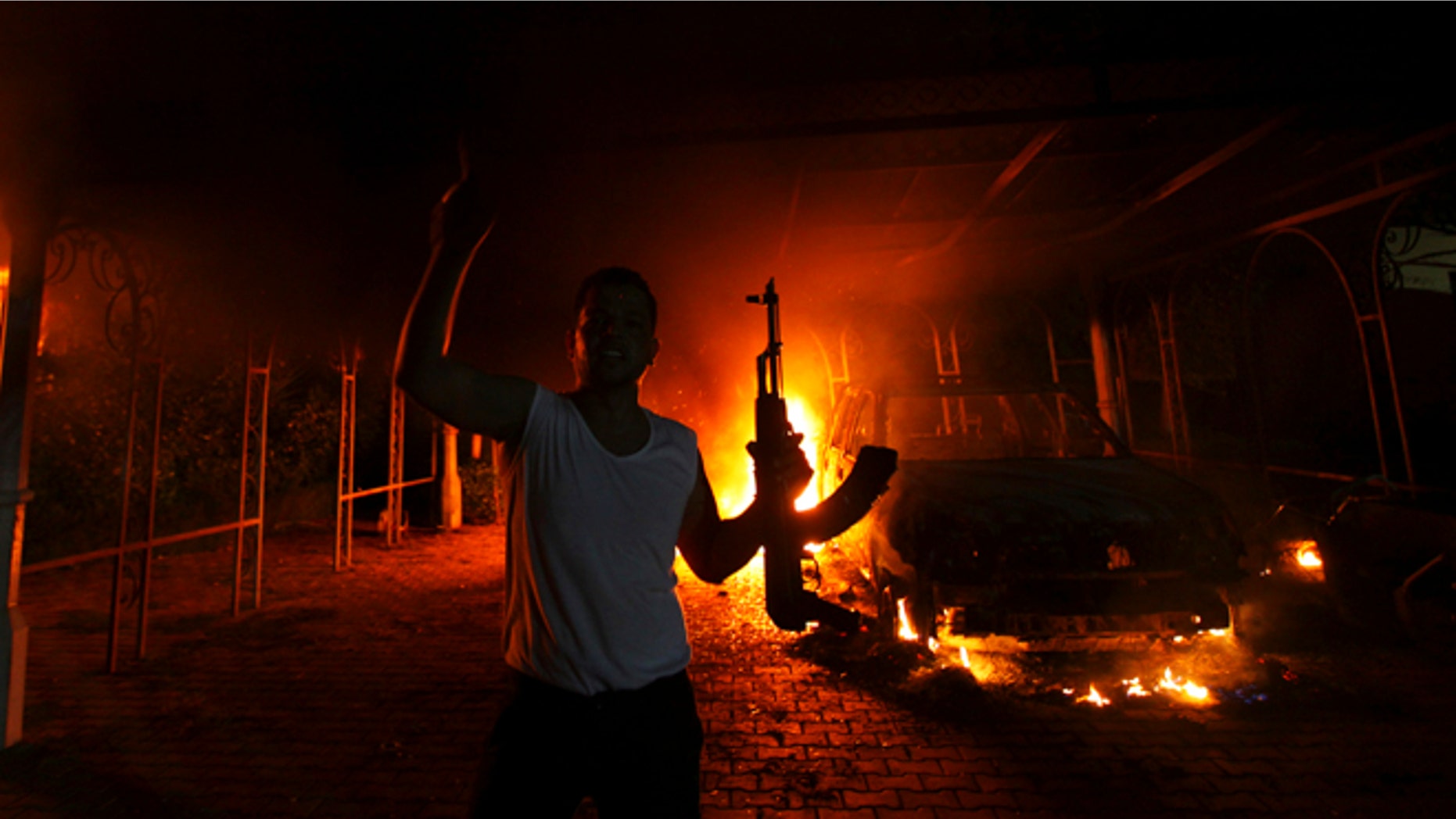 Sept. 11, 2012: A protester reacts as the U.S. Consulate in Benghazi is seen in flames during a protest by an armed group. (Reuters)