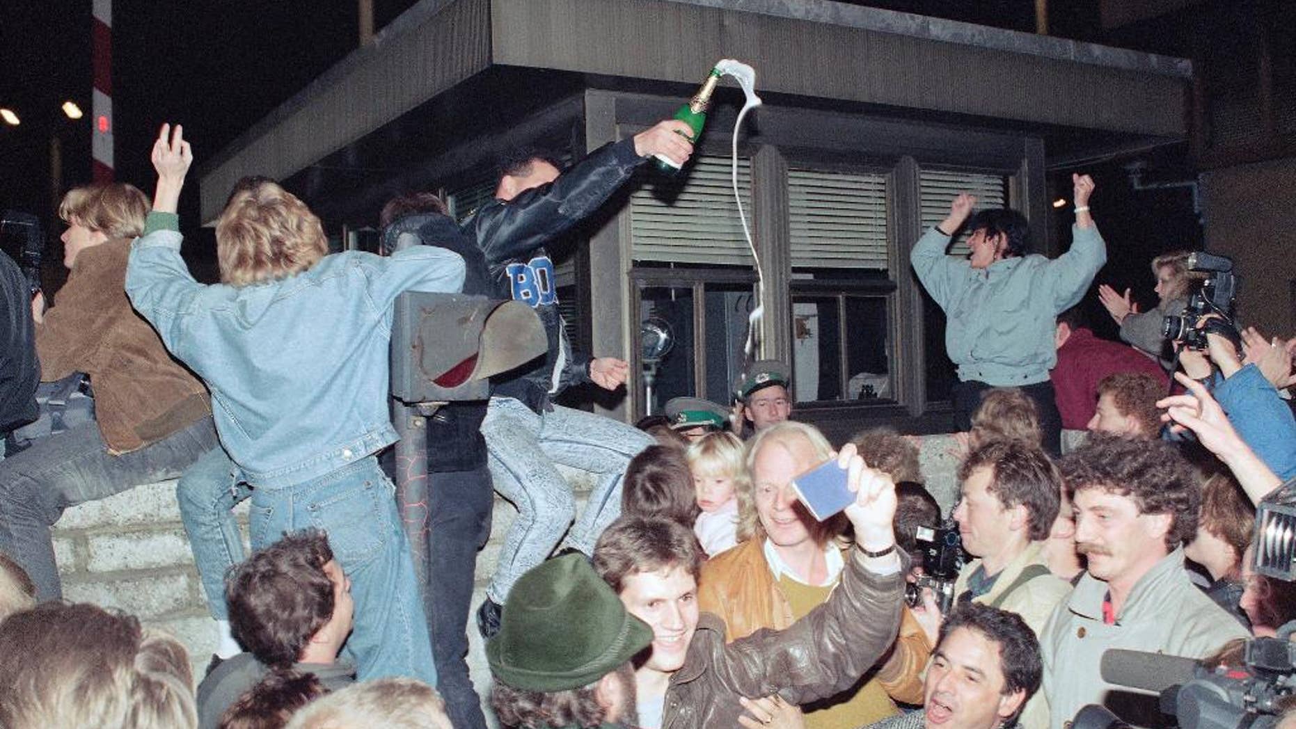 NOV. 10, 1989 - FILE PHOTO - East and West Berliners celebrating in front of a control station on East Berlin territory, during the opening of the borders to the West following the announcement by the East German government that the border to the West would be open. ADVANCE FOR RELEASE SATURDAY, NOVEMBER 8, 2014, AT 12:01 A.M