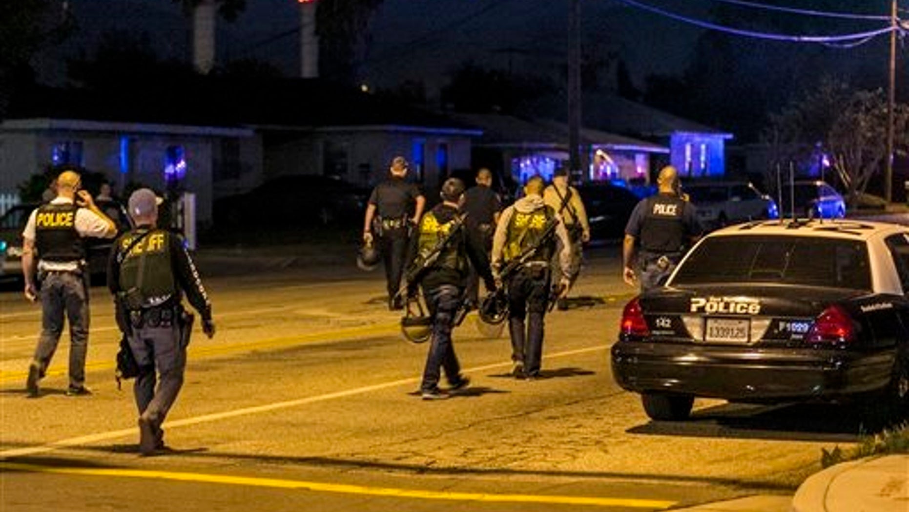 Authorities guard the perimeter near the location of an officer-involved shooting Wednesday, Dec. 2, 2015, in San Bernardino, Calif., following a shooting that killed multiple people at a social services center for the disabled. (AP Photo/Damian Dovarganes)
