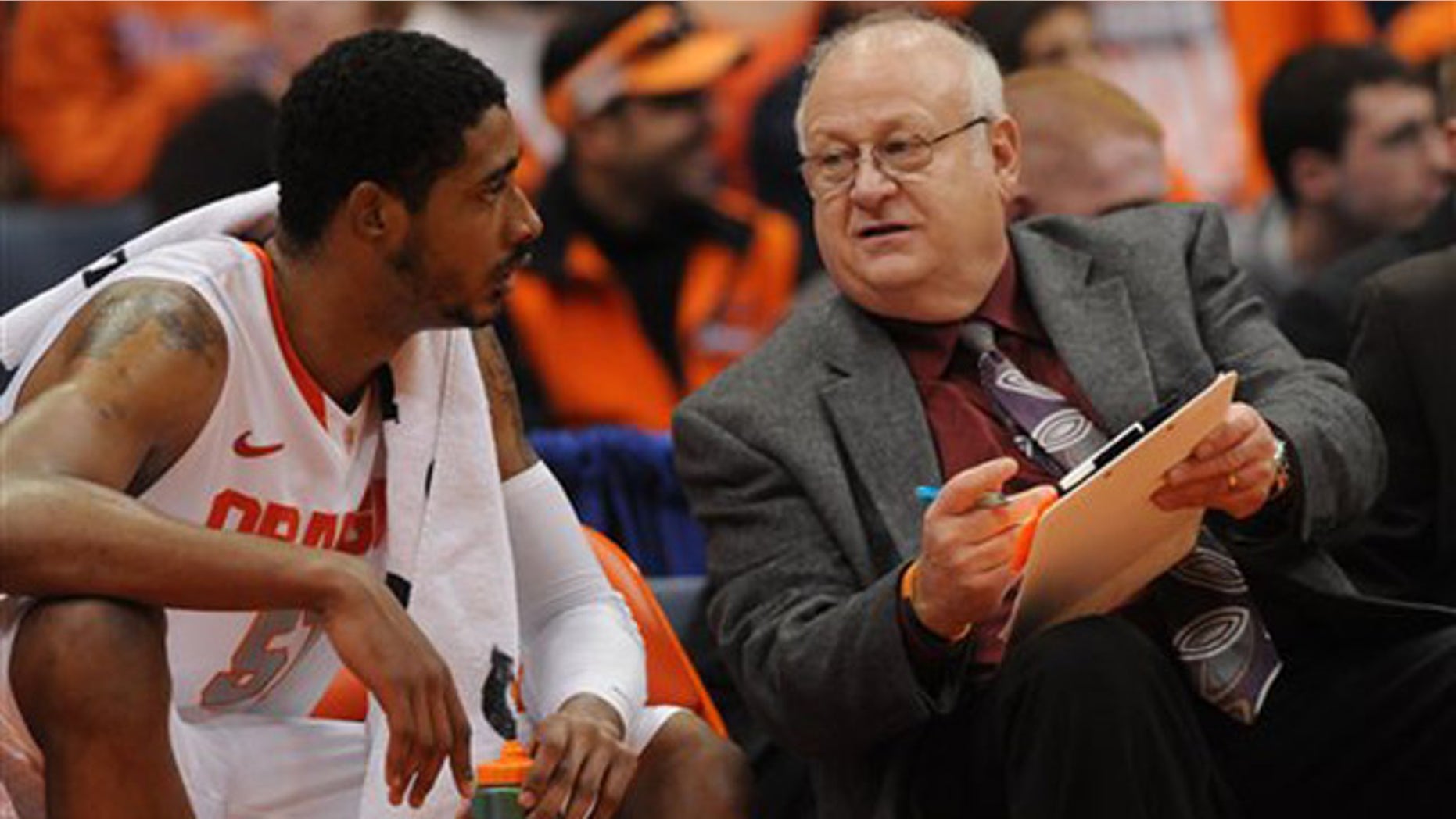 This Nov. 12, 2001 photo shows Syracuse assistant basketball coach Bernie Fine talking to Fab Melo on the bench during a game against Fordham, in Syracuse, N.Y.