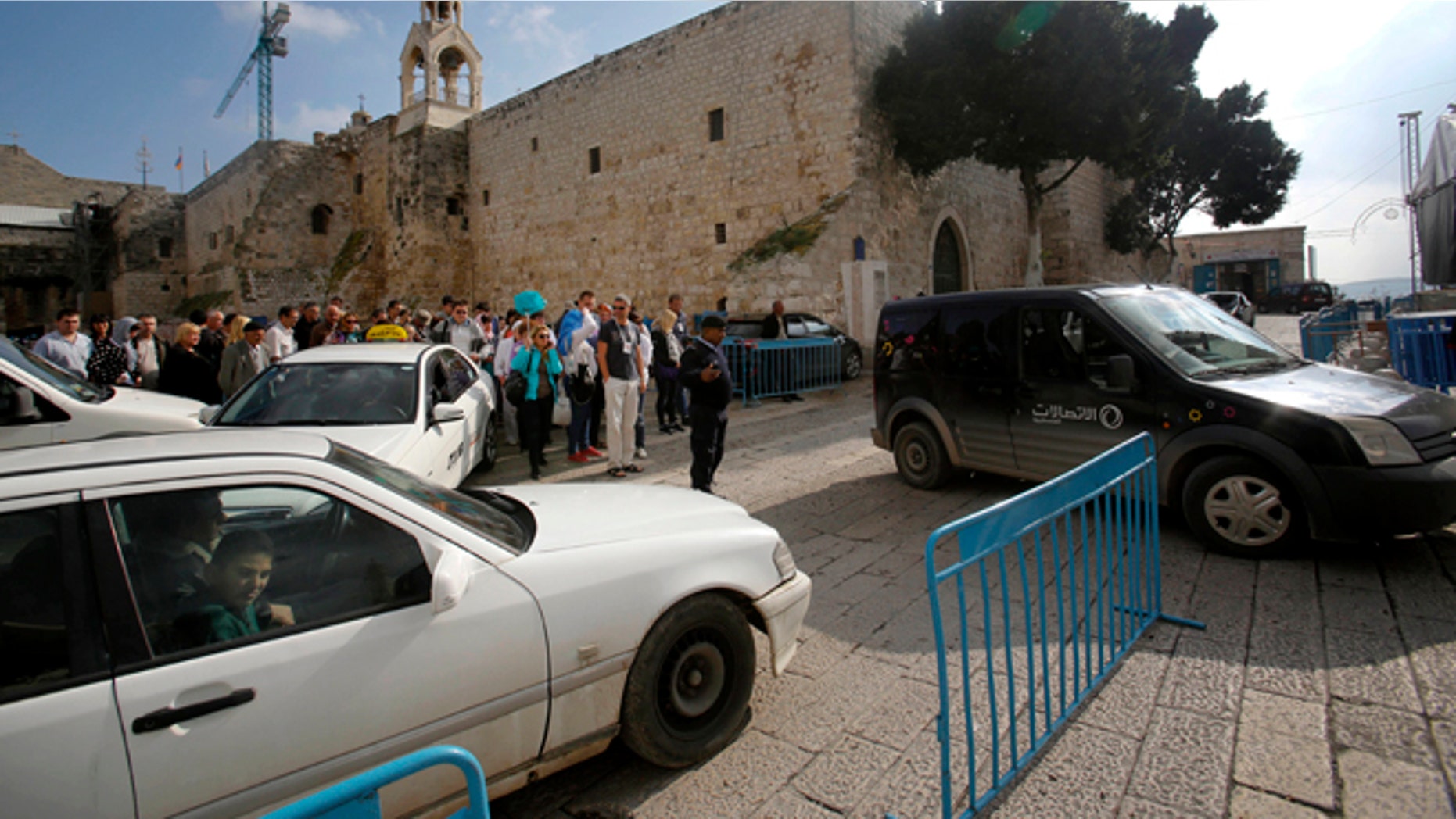 Dec. 14, 2014: Tourists walk and cars drive past the Church of the Nativity in Bethlehem, West Bank. Its Christmas season and the little town of Bethlehem is jammed with a big-city problem: Traffic snarling streets everywhere, including around the church marking the spot where tradition says Jesus was born.