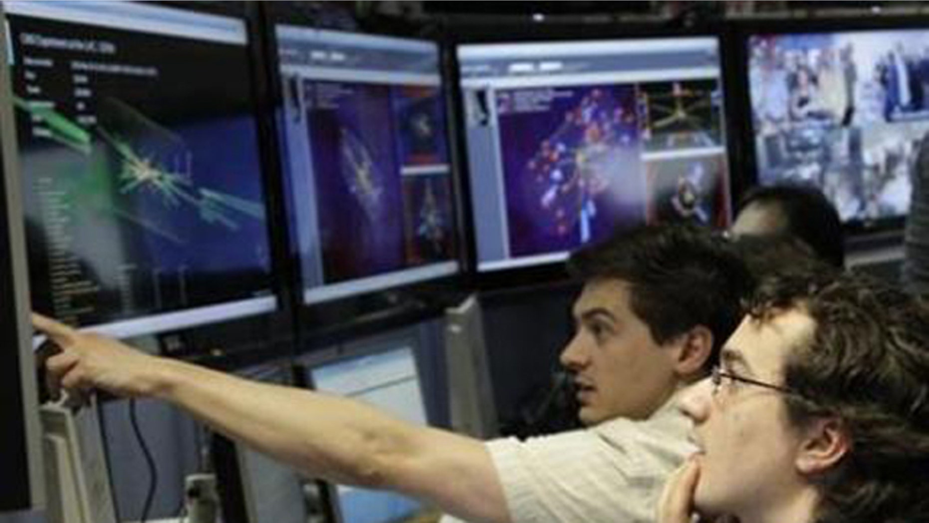 March 30: Scientists look at pictures of the first successful collisions at full power at the Compact Muon Solenoid experience control room of the Large Hadron Collider at the European Organisation for Nuclear Research in Meyrin, near Geneva.