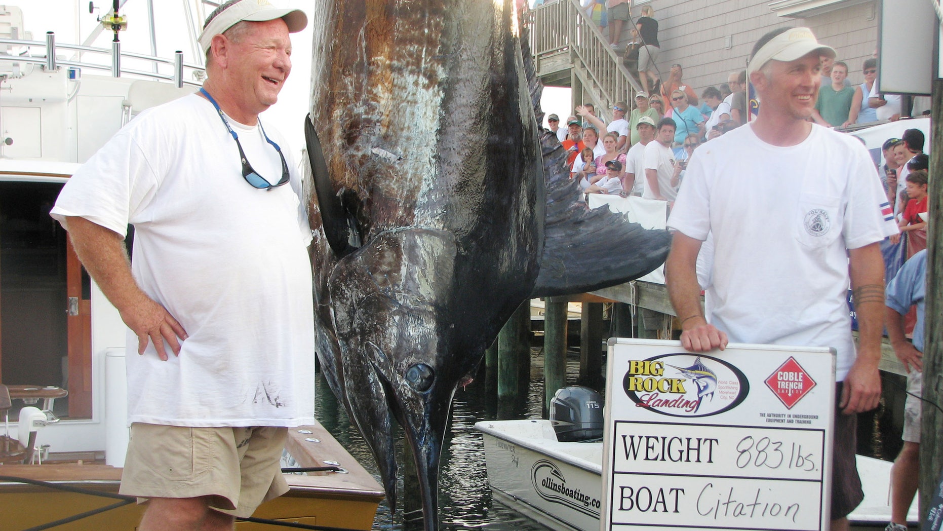 June 14, 2012: Citation angler Andy Thomossan, left, and Eric Holmes stand next to their 883-pound blue marlin, which broke the record for the biggest blue marlin in the 52-year history of the Big Rock Blue Marlin Tournament in Morehead City, N.C.