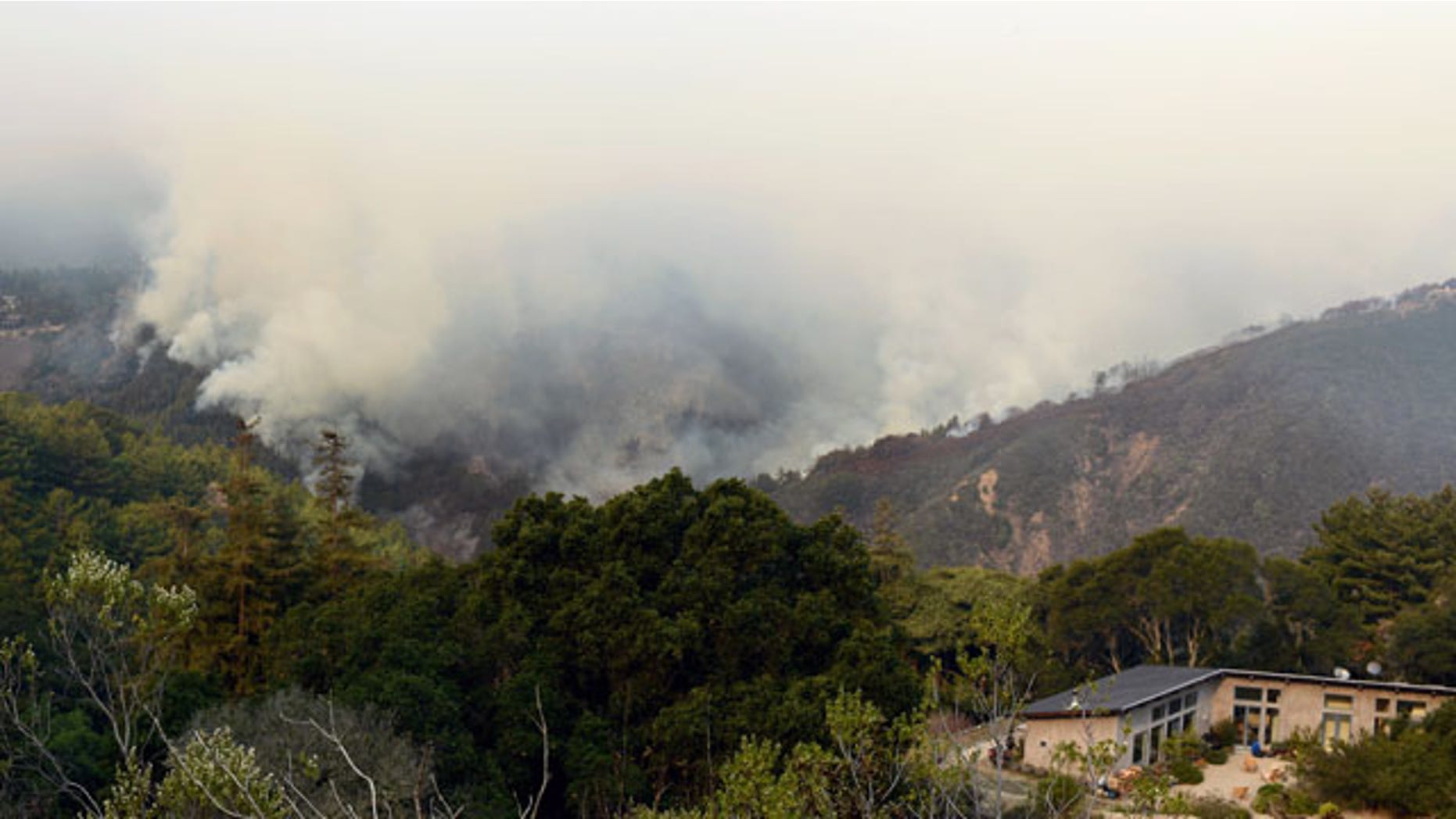 December 16, 2013: Smoke rises above Pfeiffer Ridge in Big Sur, Calif. The wildfire burning Monday in the Big Sur area of California destroyed at least 15 homes and forced about 100 people to evacuate as it chewed through dry vegetation on its way toward the ocean. (AP Photo/Nic Coury)