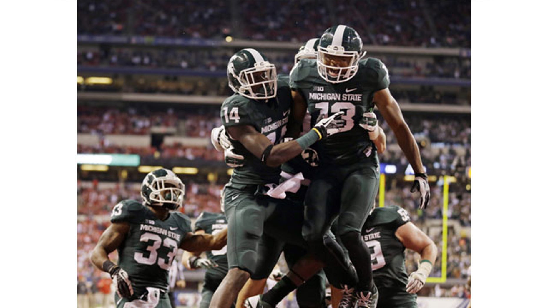 December 7, 2013: Michigan State's Tony Lippett (14) celebrates with Bennie Fowler (13) after a 33-yard touchdown reception by Lippett during the first half of the Big Ten championship game in Indianapolis. (AP Photo/Michael Conroy)