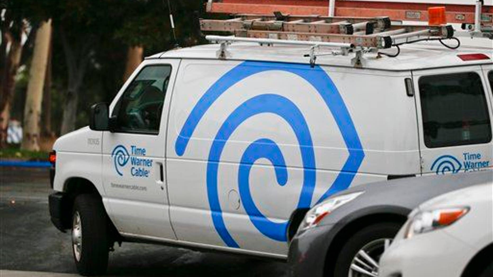 A Time Warner Cable service truck works its way through traffic May 27, 2015, in Carlsbad, Calif.
