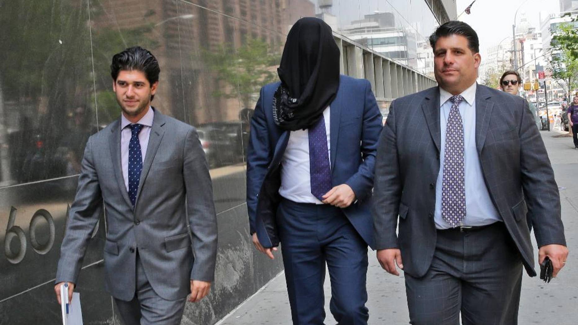 FILE - In this May 19, 2015 file photo, Wojciech Braszczok, center, is led into court with his face covered in New York. The undercover New York Police Department detective and a co-defendant were acquitted Tuesday, June 9, 2015 of the most serious charges but convicted of lesser crimes for participating in a September, 2013 motorcycle rally that devolved into highway pandemonium as an SUV driver was pulled from his window and beaten bloody in front of his wife and toddler. (AP Photo/Mary Altaffer, File)
