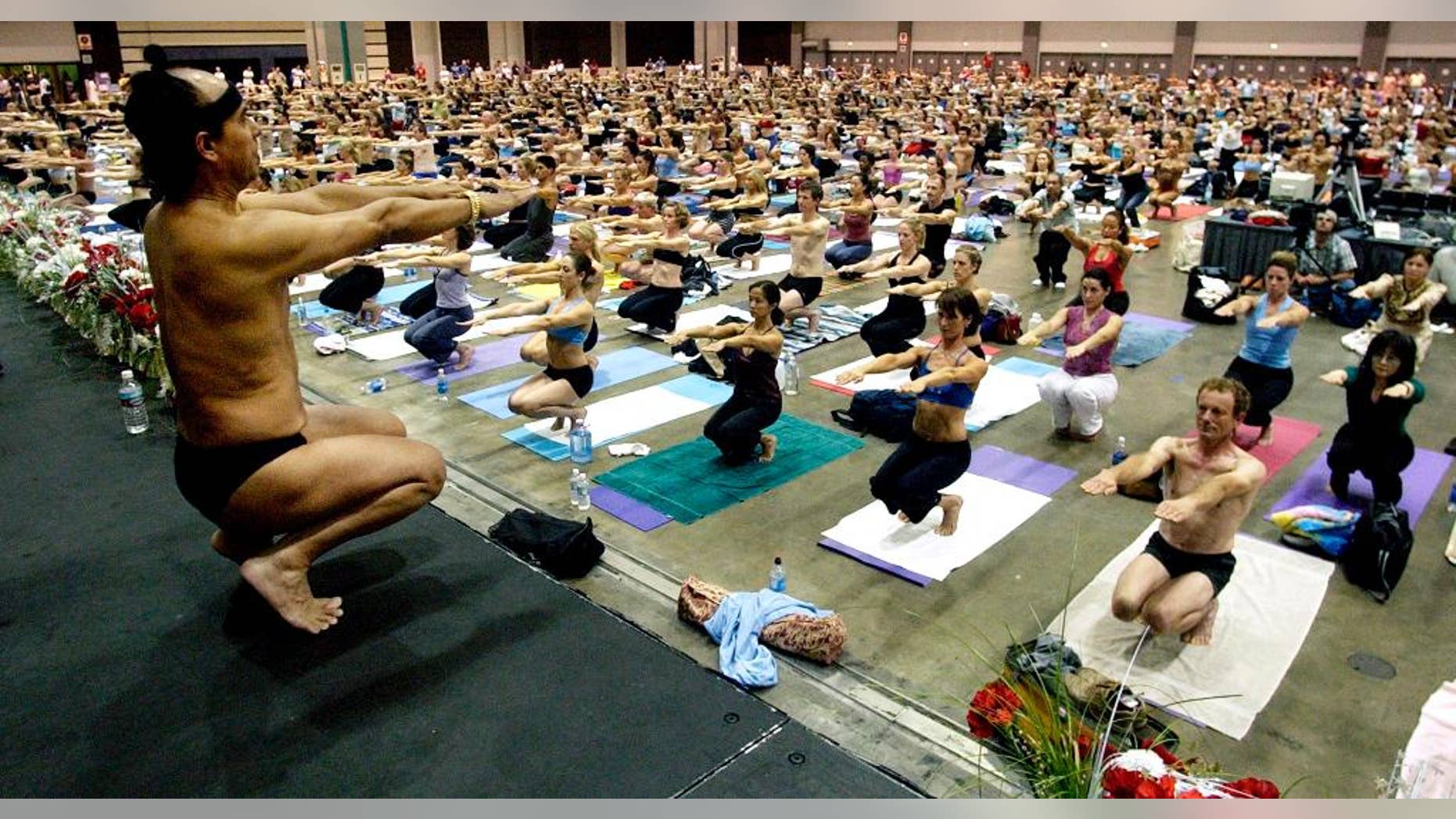 FILE - This Sept. 27, 2003 file photo Bikram Choudhury, front, founder of the Yoga College of India and creator and producer of Yoga Expo 2003, leads a yoga class at the Expo at the Los Angeles Convention Center. A half-dozen women claim Choudhury, the founder of the popular hot yoga studios that bear his name groped, harassed or sexually assaulted them. The most recent case filed this month claims that Choudhury raped a former student in 2010. (AP Photo/Reed Saxon,File)