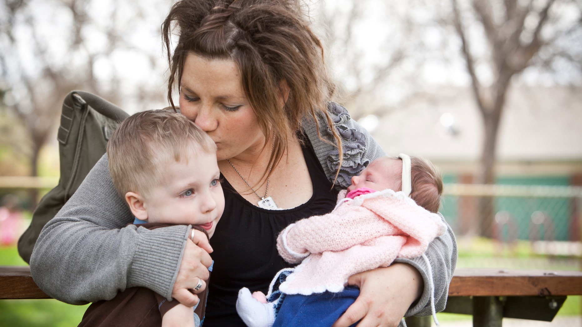 Rachel Rabey and her children sit in Ann Morrison Park in Boise, Id. While in labor in 2010, Rabey let paramedics drive past two nearby hospitals to a third facility in Boise, adding minutes to a journey that ended in the death of her newborn child. (AP Photo/The Idaho Statesman, Chris Butler)