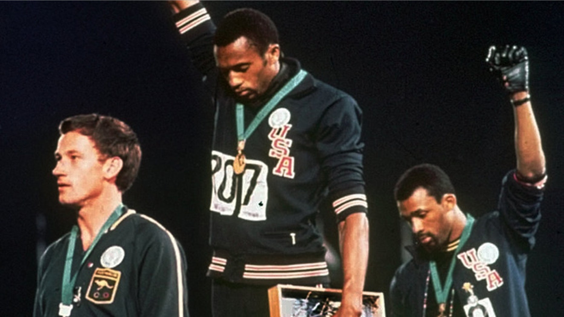 Oct. 16, 1968: In this file photo, United States gold medalist Tommie Smith, center, and bronze medalist John Carlos, right, stare downward while extending their gloved hands skyward in racial protest alongside Australian silver medalist Peter Norman during the playing of "The Star Spangled Banner"following the 200-meter race at the Mexico City Summer Olympics.