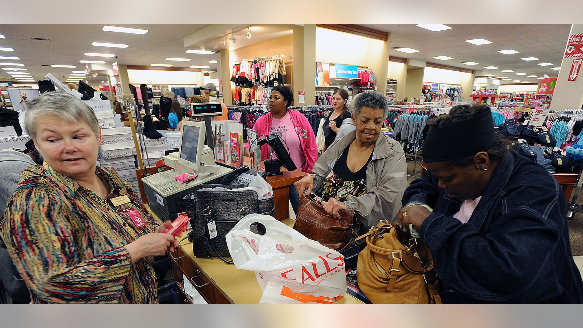 FILE: Thursday, Nov. 22, 2012: Linda Robinson runs the register for shoppers Maxine Rocquemore, center, and Romona Rocquemore at the Bealls Department Store in Nacogdoches, Texas.