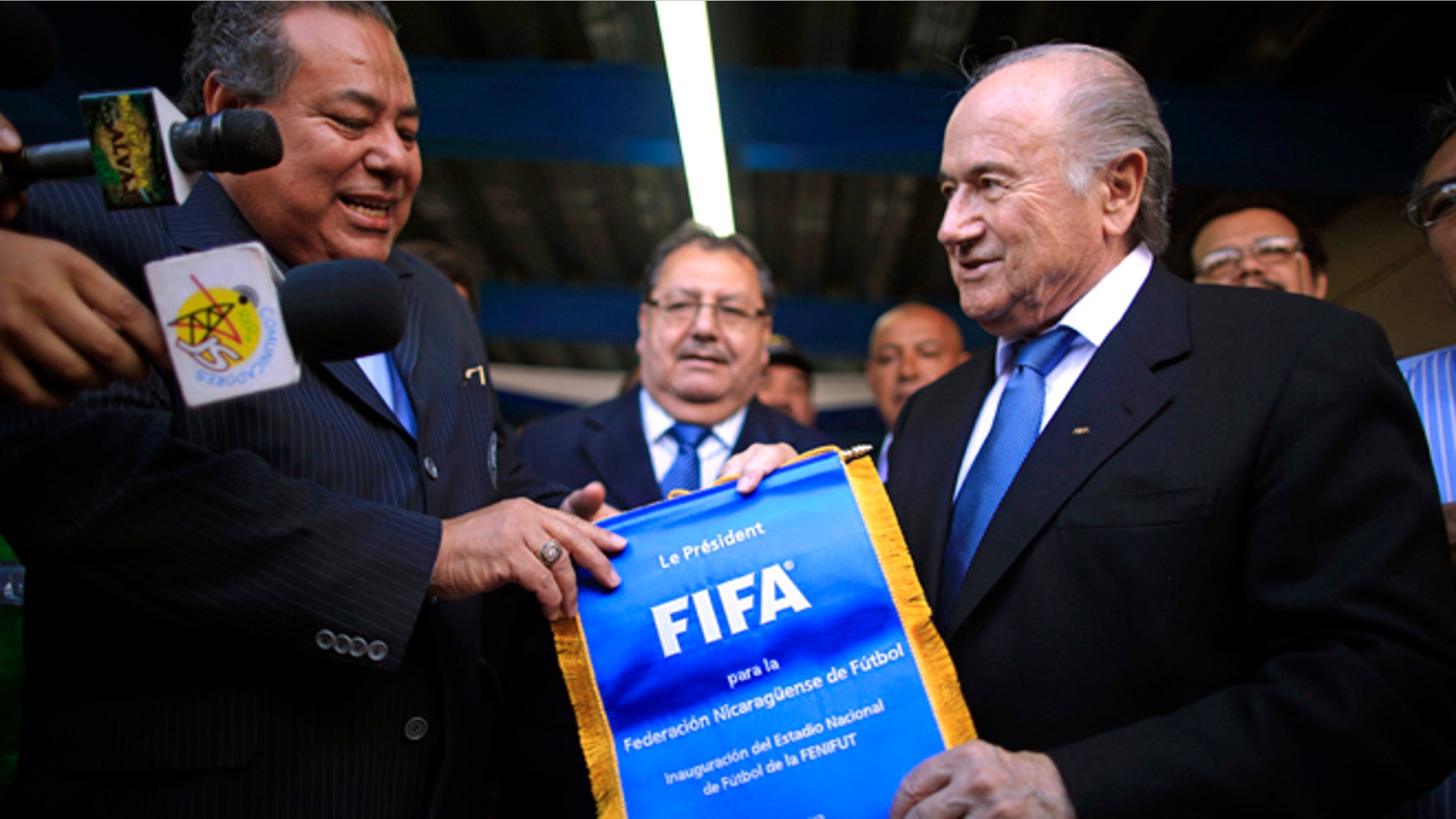FILE - In this Thursday April 14, 2011 file photo FIFA President Sepp Blatter, right, gives a FIFA pennant to Nicaragua's Soccer Federation President Julio Rocha during the inauguration of the construction of a new National Soccer Stadium in Managua, Nicaragua. Rocha is among the soccer officials that were arrested and detained by Swiss police on Wednesday, May 27, 2015, at the request of U.S. authorities after a raid at Baur au Lac Hotel in Zurich. (AP Photo/Esteban Felix, File)