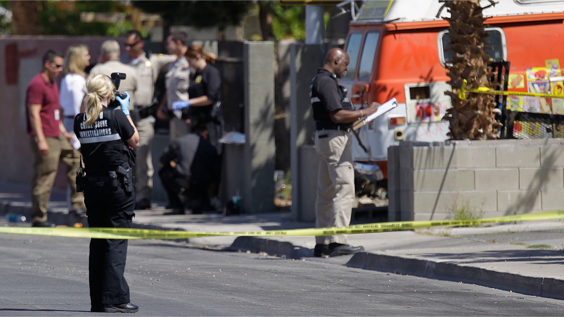 Crime scene investigators examine the scene of a home where two bodies and an injured man were found, Monday, April 16, 2012, in Las Vegas. Police are questioning a man covered in blood at the home where a 9-year-old boy told school officials his mother and sister were dead. (AP Photo/Julie Jacobson)