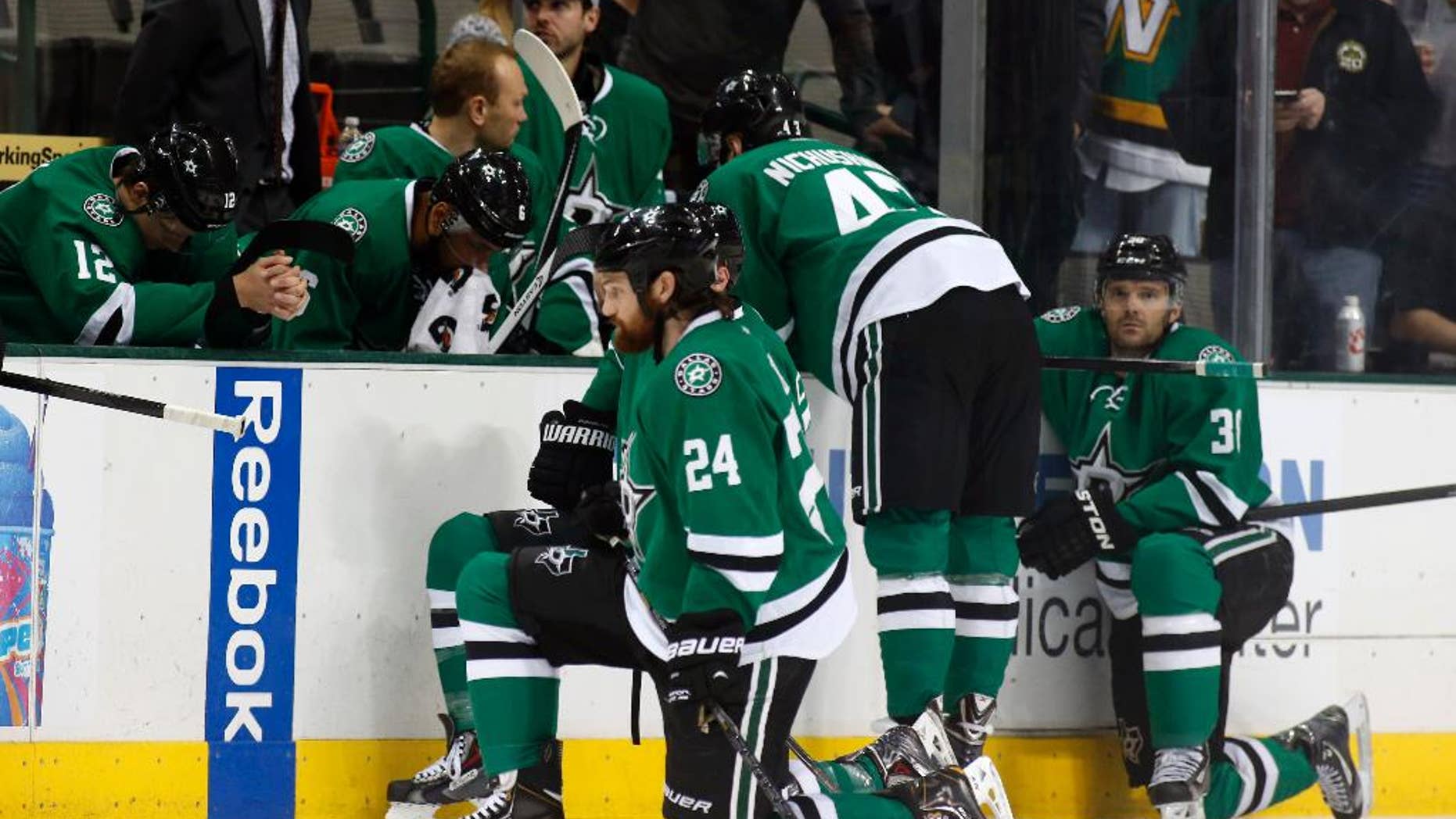 Dallas Stars right wing Alex Chiasson (12) bows his head on the bench as defenseman Jordie Benn (24) takes a knee on the ice after play was stopped in the first period of an NHL Hockey game against the Columbus Blue Jackets, Monday, March 10, 2014, in Dallas. Stars center Rich Peverly was taken to a hospital after a medical emergency. (AP Photo/Sharon Ellman)