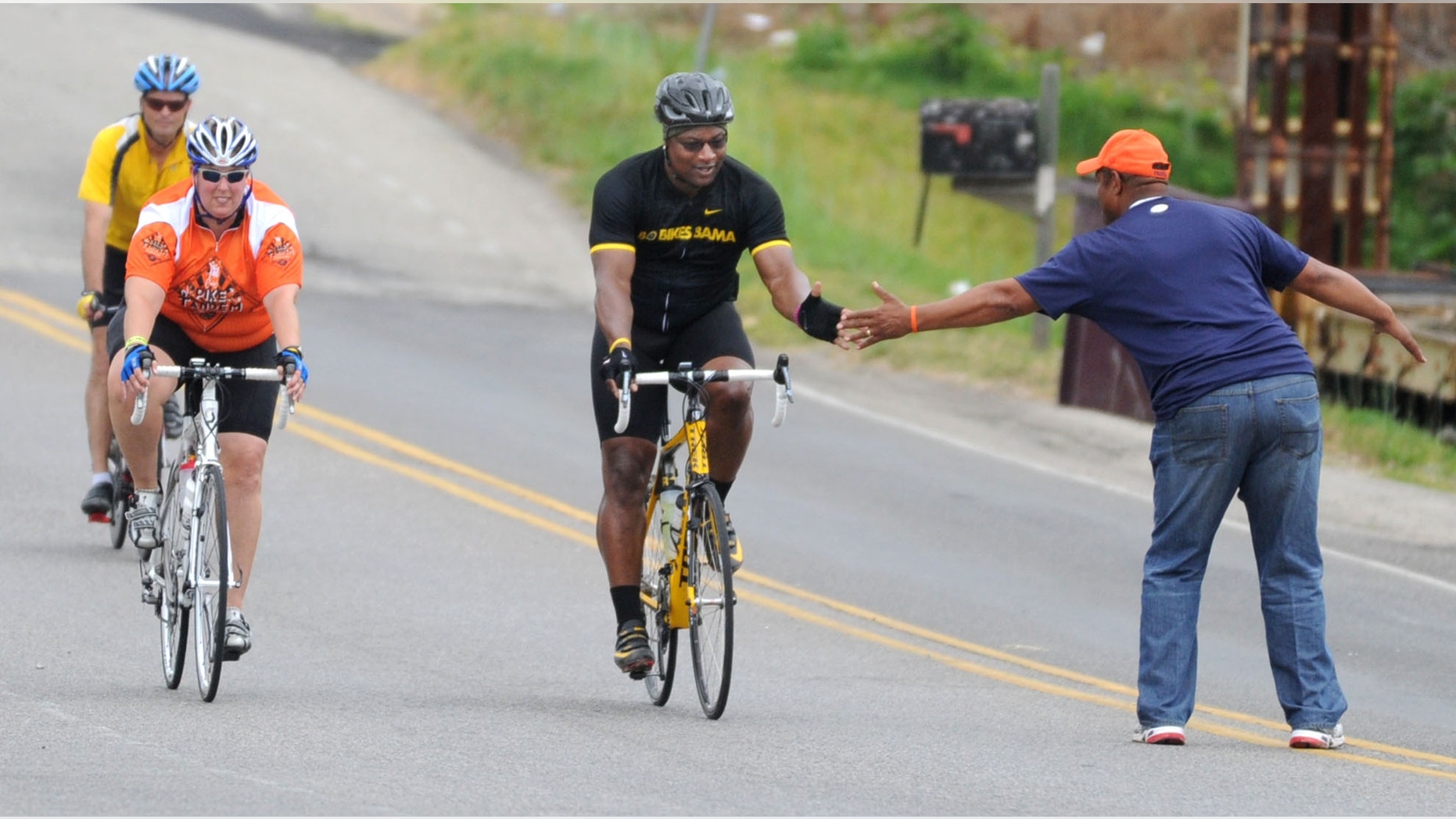 April 27, 2012: Bo Jackson greets a fan as he pedals to Jack's restaurant in Pleasant Grove, Ala.