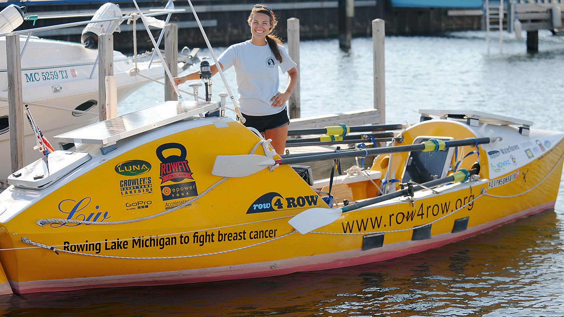 July 12, 2012: Jenn Gibbons poses with her 19-foot ocean rowing boat at a marina in Menominee, Mich.