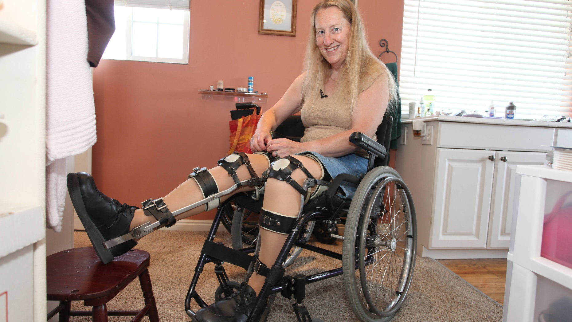 Chloe Jennings-White adjusting her leg braces at her home in Salt Lake City, Utah. Chloe-Jennings White wears leg braces and uses a wheelchair, even though her legs work fine, and she does not need them.