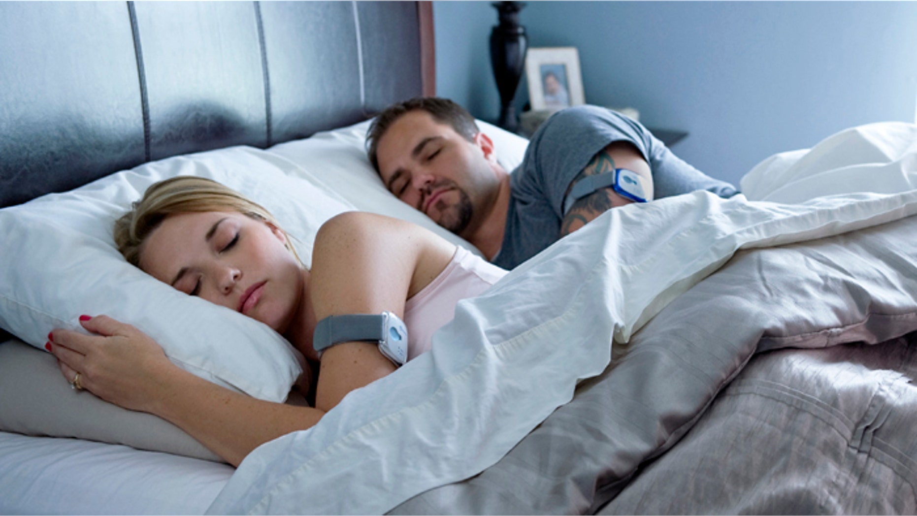 A couple sleeps while wearing the BodyMedia FIT