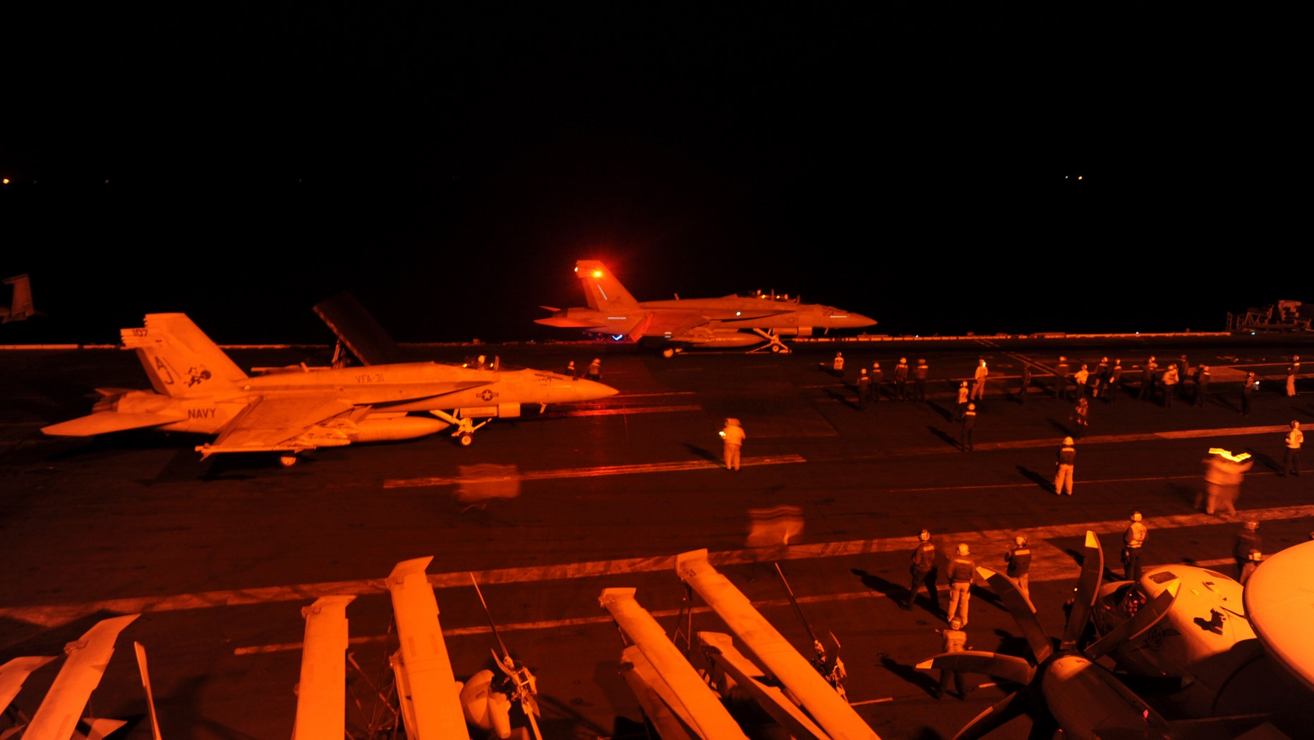 An F/A-18E Super Hornet, attached to Strike Fighter Squadron (VFA) 31, and an F/A-18F Super Hornet, attached to Strike Fighter Squadron (VFA) 213, prepare to launch from the flight deck of the aircraft carrier USS George H.W. Bush (CVN 77) to conduct strike missions against ISIL targets, in the Arabian Gulf.