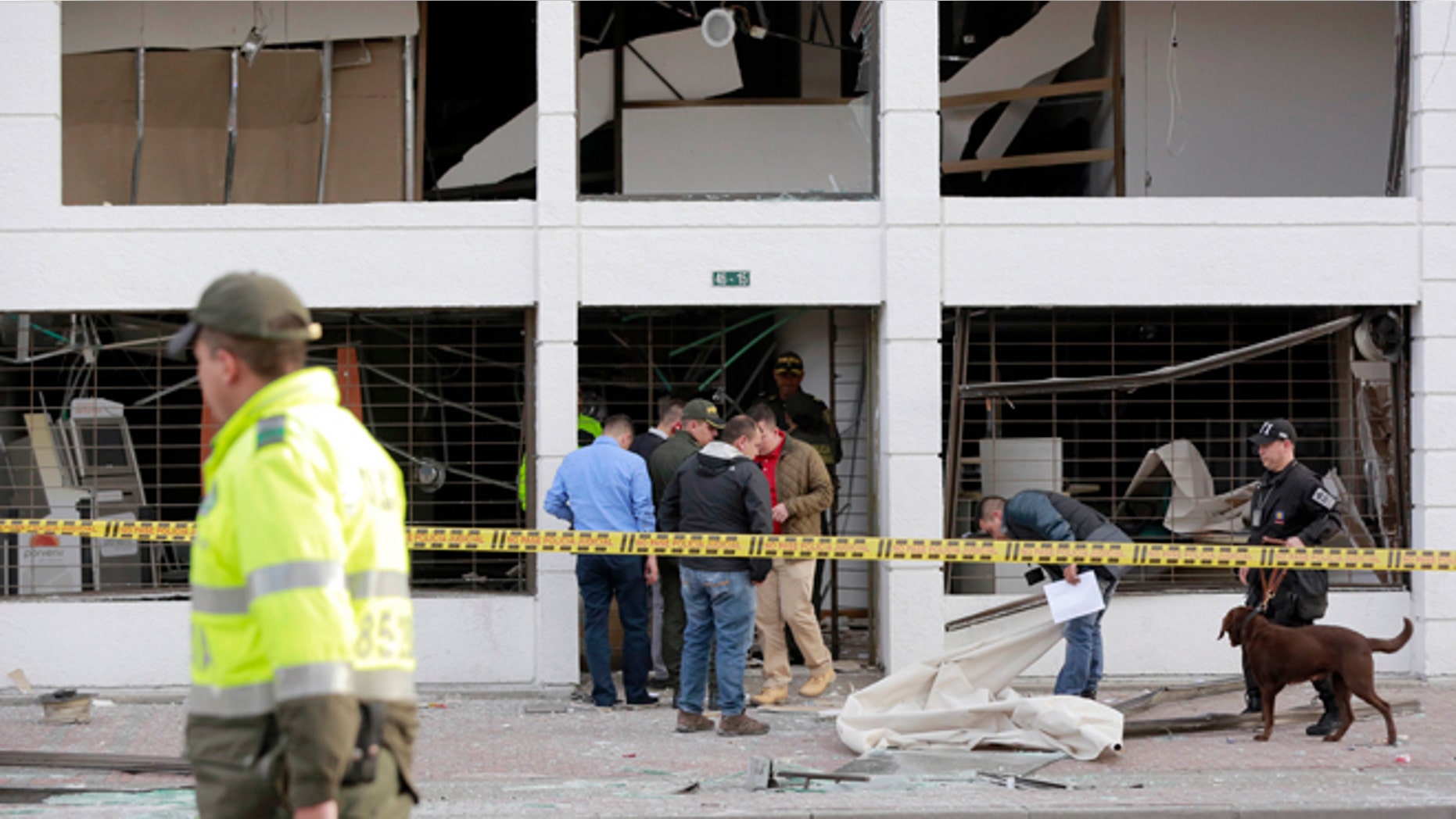 Police officers inspect an office after it was wrecked by an explosion in Bogota, Colombia, Thursday, July 2, 2015. A homemade explosive device went off in the financial district of Colombia's capital and wounded several people, while a second blast elsewhere in Bogota injured another, authorities said. (AP Photo/Fernando Vergara)