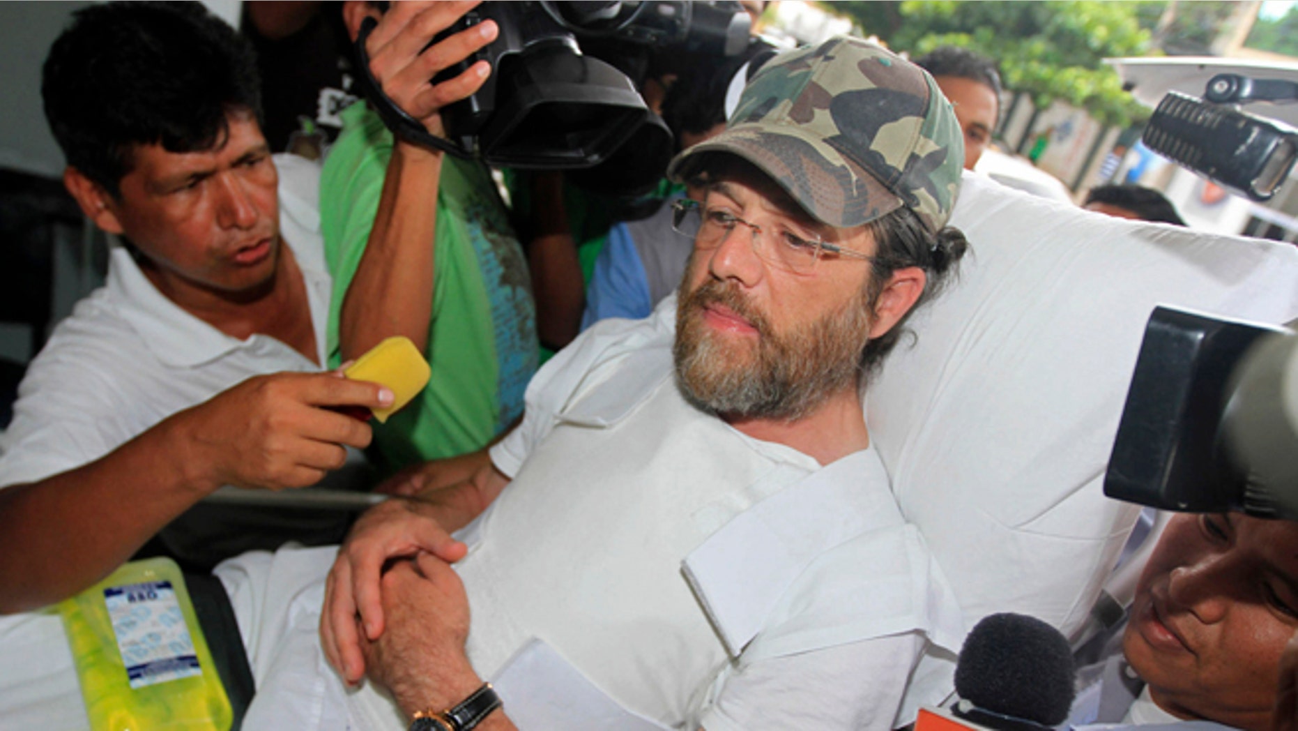 Members of the press surround U.S. businessman Jacob Ostreicher as he arrives in a hospital bed wearing a flak jacket to his court hearing in Santa Cruz, Bolivia, Tuesday, Dec. 11, 2012. A Bolivian appeals panel has refused to immediately release Ostreicher, despite evidence he was fleeced and extorted by prosecutors who have had him jailed for 18 months without charges on suspicion of money laundering. Ostreicher has been hospitalized for more than two weeks in a private clinic after being diagnosed with Parkinsons. (AP Photo)