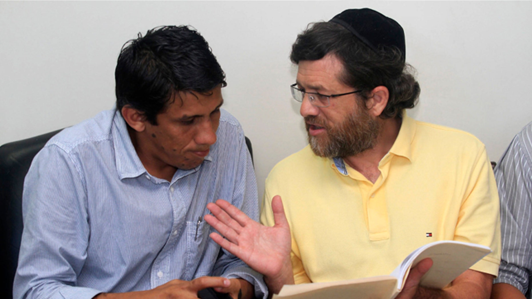 FILE - In this March 21, 2012 file photo, U.S. businessman Jacob Ostreicher, right, talks to his attorney Abel Montano at a local courthouse in Santa Cruz, Bolivia. In an unlikely tale, the Orthodox Jew from New York City came to Bolivia to rescue a rice-growing venture, was thrown in jail on suspicion of money laundering and, with the aid of actor Sean Penn, winds up triggering one of the biggest scandals of Evo Morales' presidency. The saga came to light 18 months ago when Ostreicher was arrested while trying to salvage a multimillion-dollar investment he was managing for Swiss partners. After Penn directly interceded on Ostreicherâs behalf, it could now be reaching its end game. (AP Photo/File)
