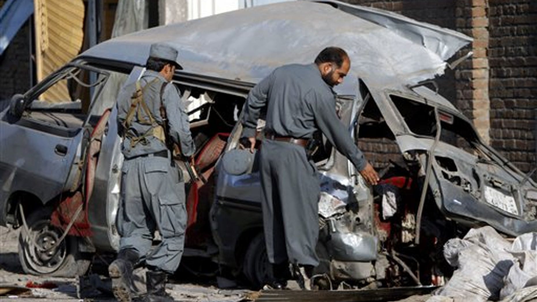 April 21: Afghan police officials investigate a damaged vehicle at the site of an explosion in Jalalabad, Nangarhar province east of Kabul, Afghanistan.