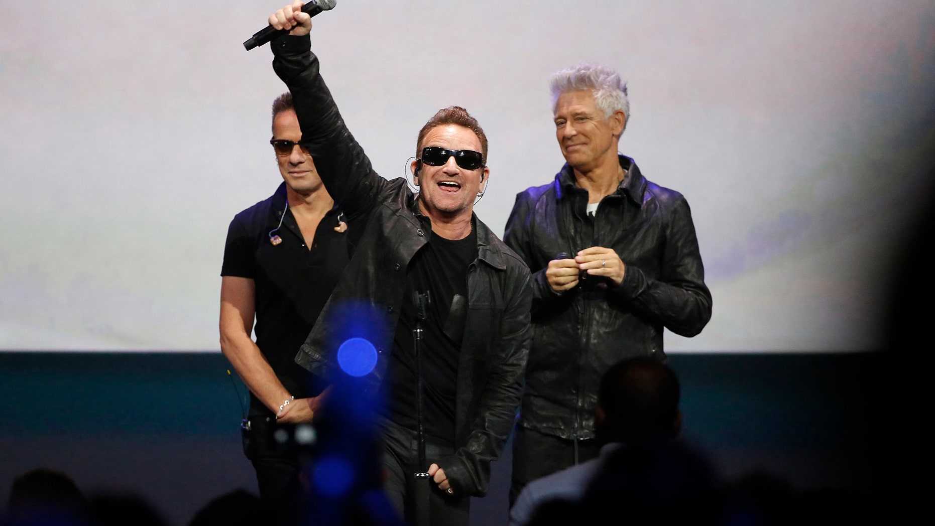Bono (C) of Irish rock band U2 gestures to the audience after performing at an Apple event at the Flint Center in Cupertino, California, September 9, 2014. REUTERS/Stephen Lam (UNITED STATES - Tags: BUSINESS ENTERTAINMENT SCIENCE TECHNOLOGY TPX IMAGES OF THE DAY) - RTR45LHD