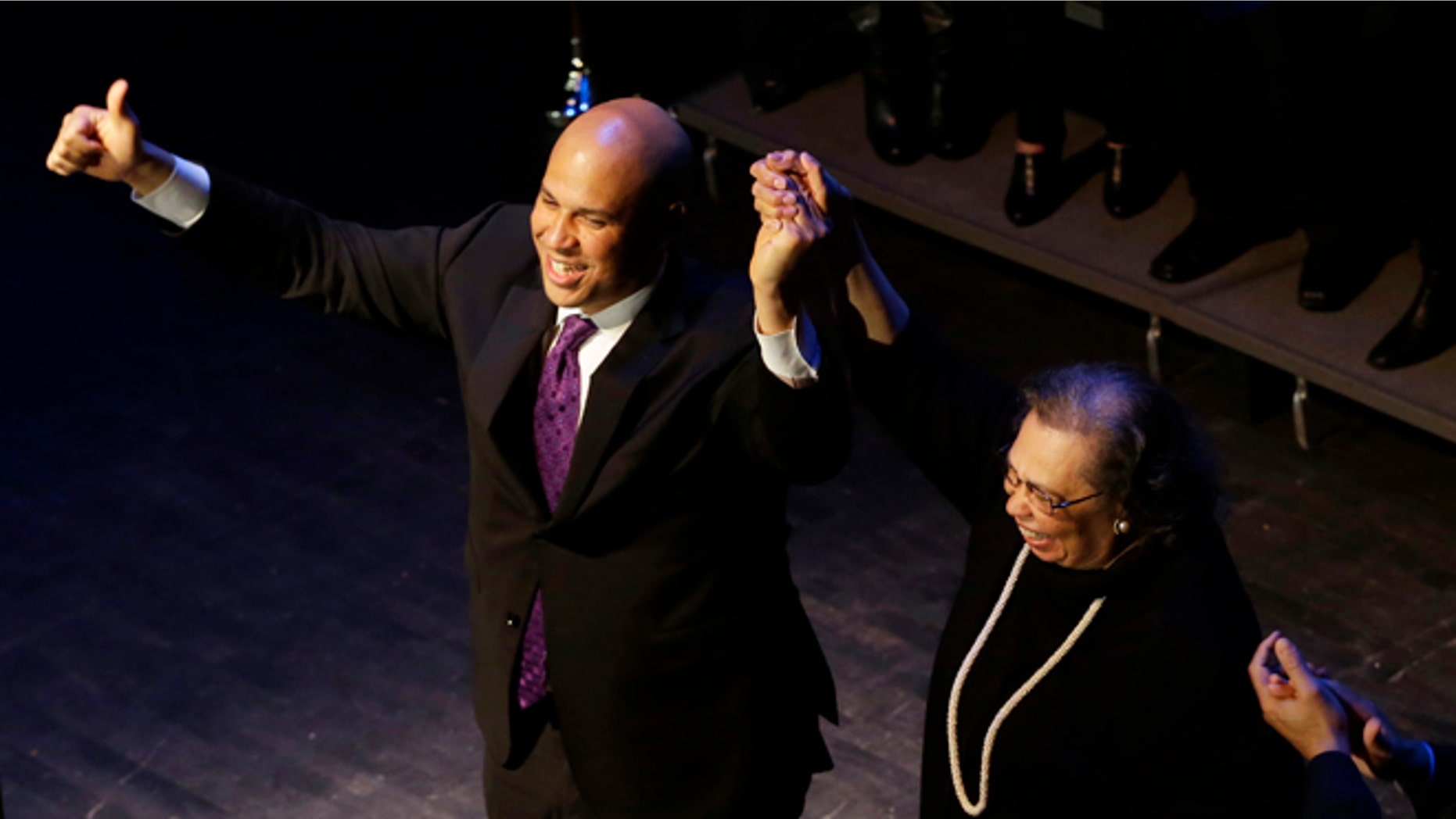 Wednesday, Oct. 16, 2013: Newark Mayor Cory Booker, left, holds the hand of his mother Carolyn Booker after his victory speech during an election night party, Newark, N.J.
