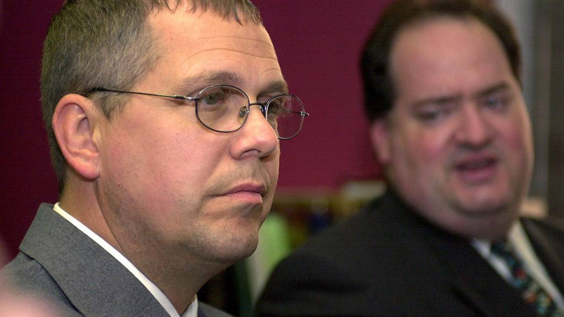 File-This Sept. 8, 2005, file photo shows Customs and Border Protection Officer Robert Rhodes listening to his defense attorney, Steven Cohen, during a press conference after the verdict from the U.S. Federal Courthouse in Buffalo, N.Y. The United States is defending itself against a Chinese tourist’s $10 million injury claim with the testimony of a surprising witness a border officer the government initially fired and charged in the case. Rhodes says he was eager to testify in the lawsuit filed by Zhao Yan, being tried now in Rochester, even though the government’s prosecution of him left him bankrupt. He says he was glad to be able to tell his side of the story. (AP Photo/Don Heupel, File)
