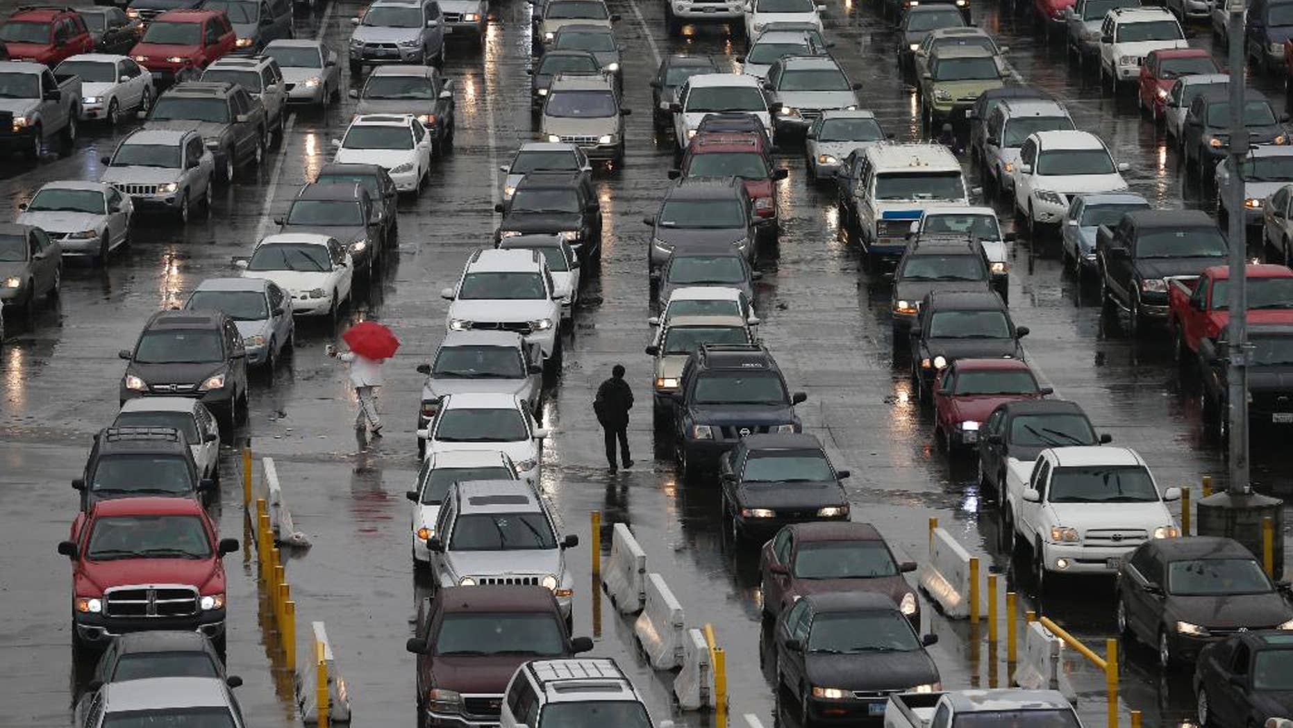 FILE - In this Dec. 3, 2014 file photo, cars wait to enter the United States from Tijuana, Mexico through the San Ysidro port of entry in San Diego. San Diego police say a 40-year-old man died after a border inspector shot him with a stun gun at the nation's busiest crossing. Police said Thursday, Dec. 25, 2014 that the man jumped over a counter and attacked an inspector after being escorted to a separate area for questioning at the San Ysidro port of entry between San Diego and Tijuana, Mexico and a records check revealed he was wanted on a felony charge. (AP Photo/Gregory Bull)