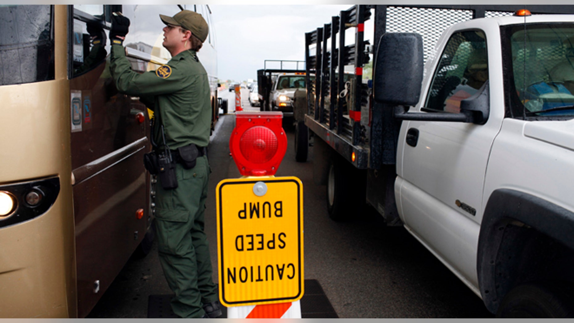 FILE - This July 29, 2010 file photo shows a Border Patrol agent checking the identification card of a bus driver at a checkpoint in Amado, Ariz. The American Civil Liberties Union reported Wednesday Jan. 15, 2014 that border patrol agents at checkpoints across southern Arizona are routinely violating the constitutional rights of U.S. residents, including unjustified detentions and illegal searches as a pretext to investigating other criminal activity in violation of the agency's mandate that stops be limited to inquiring about citizenship and visually inspecting vehicles. (AP Photo/Jae C. Hong, file)
