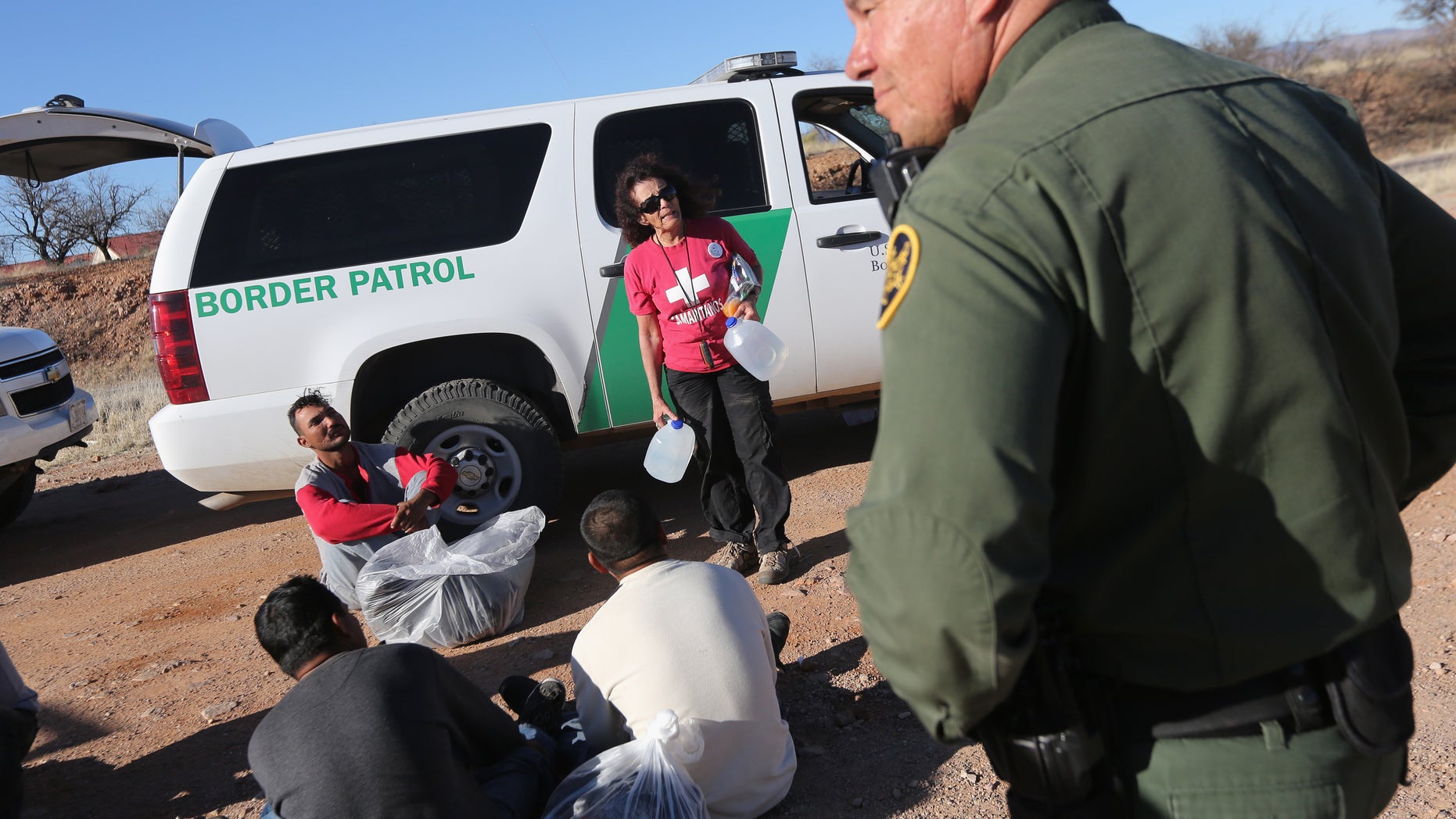 WALKER CANYON, AZ - MARCH 06: U.S. Border Patrol agents guard a group of Mexican immigrants caught after they crossed illegally into the United States on March 6, 2013 near Walker Canyon, Arizona. Elisa Hauptman, a volunteer for the non-profit Samaritans group, arrived to offer water to the detained immigrants. Due to broad federal sequestration budget cuts, Border Patrol agents are expected to begin taking unpaid furlough days in April, as Customs and Border Protection funding is expected to be reduced by more than $500 million. (Photo by John Moore/Getty Images)