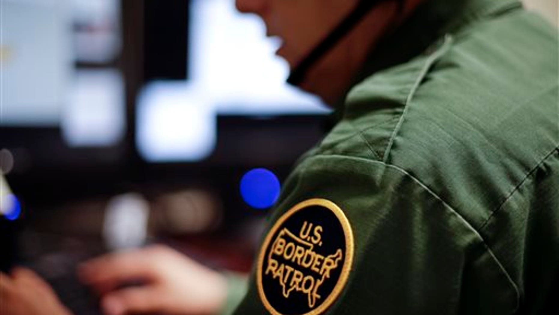 In this June 5, 2014 photo, a Border Patrol agent uses a headset and computer to conduct a long distance interview by video with a person arrested crossing the border in Texas, from a facility in San Diego. Hit with a dramatic increase of Central Americans crossing in South Texas, the Border Patrol is relieving staffing woes by enlisting agents in less busy sectors to process arrests through video interviews. (AP Photo/Gregory Bull)