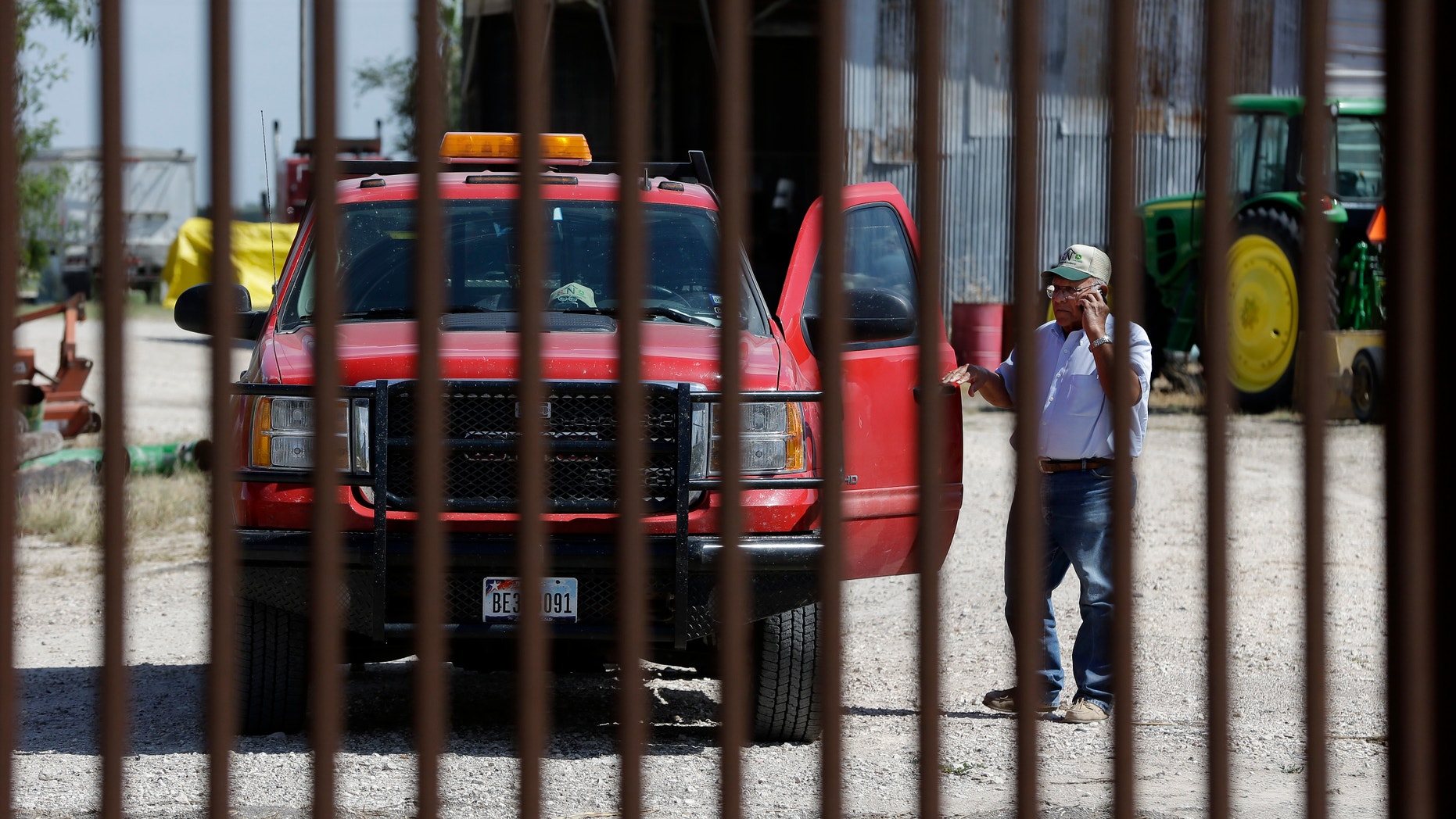 Sept. 6, 2012: Cotton farmer Teofilo “Junior” Flores stands on one side of the U.S.-Mexico border fence that passes across his property in Brownsville, Texas.