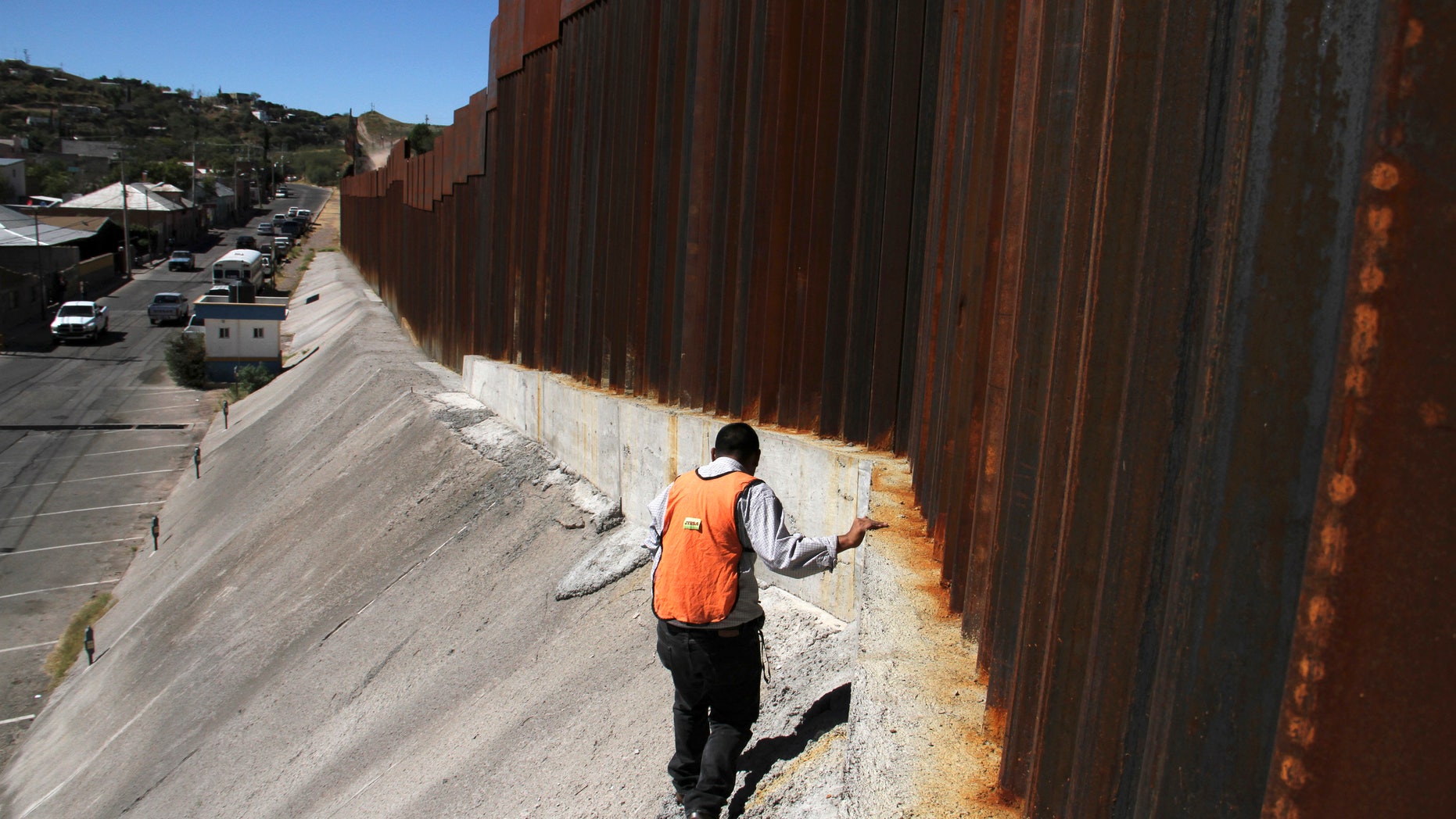 FILE: Oct. 12, 2012: An investigator inspects a crime scene where a suspected drug smuggler was shot by a U.S. Border Patrol agent on the Mexico-Arizona border.