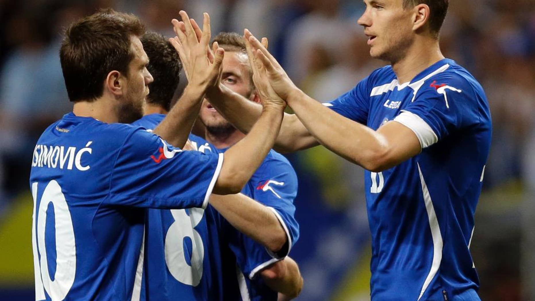 Bosnia-Herzegovina's Edin Dzeko, right, is congratulated by Zvjezdan Misimovic, left, after scoring during the second half in an international friendly soccer match against Ivory Coast on Friday, May 30, 2014, in St. Louis. Dzeko score both goals in the team's 2-1 victory. (AP Photo/Jeff Roberson)