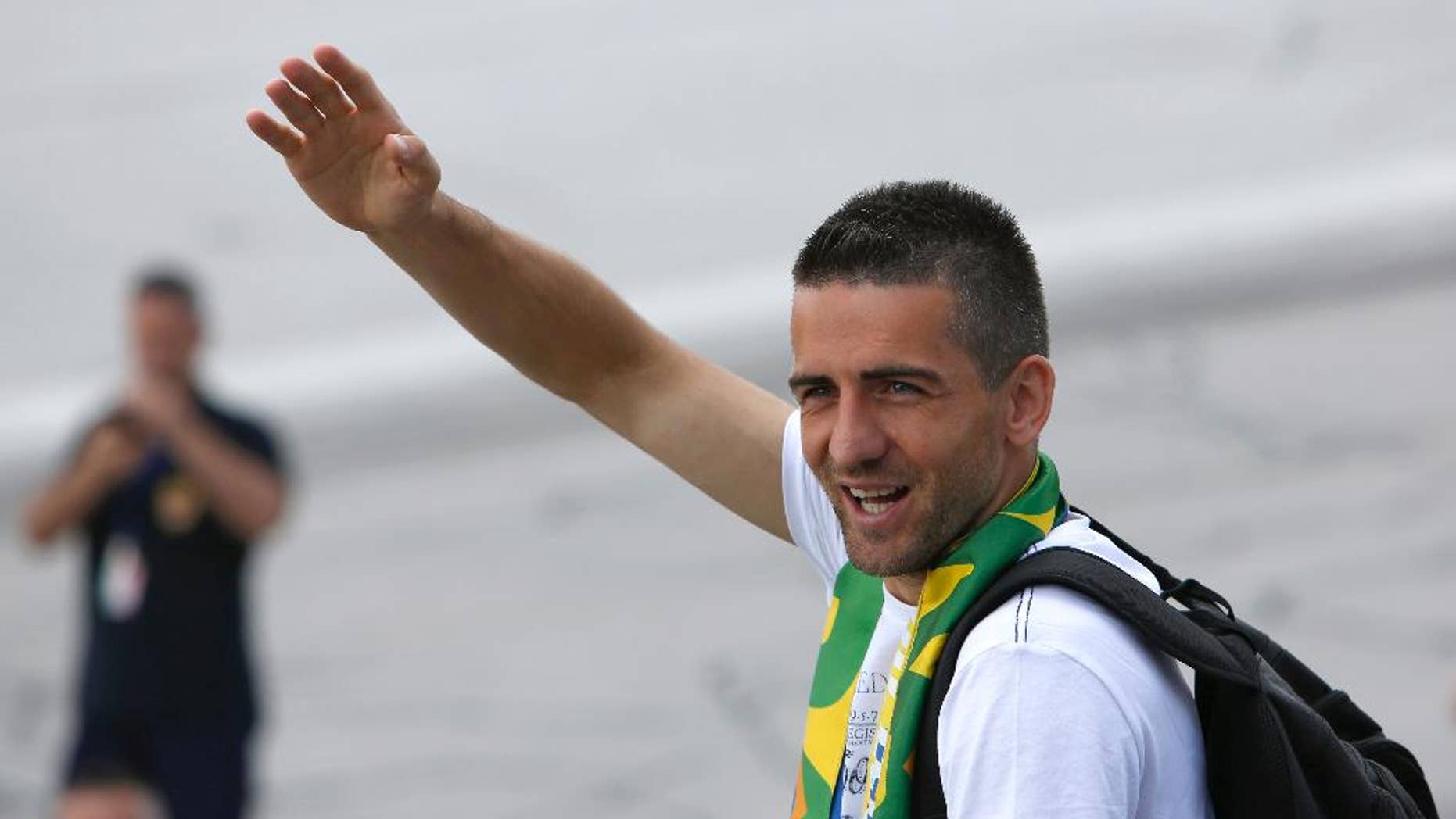 Bosnia's player Vedad Ibisevic waves to supporters at Sarajevo Airport, Bosnia, Tuesday, May 27, 2014 from where they are flying to the United States to play pre-World Cup friendly matches. Bosnia will face Argentina, Iran and Nigeria in group F of the World Cup finals of Brazil 2014. (AP Photo/Amel Emric)
