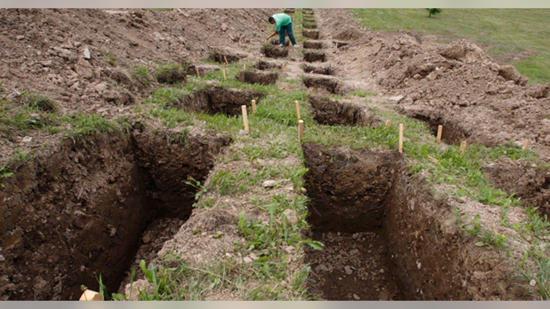 July 7: Bosnian worker inspects graves during preparation for mass burial at the memorial centre for Srebrenica victims in Potocari, near Srebrenica 120 kms northeast of Bosnian capital of Sarajevo. (AP)