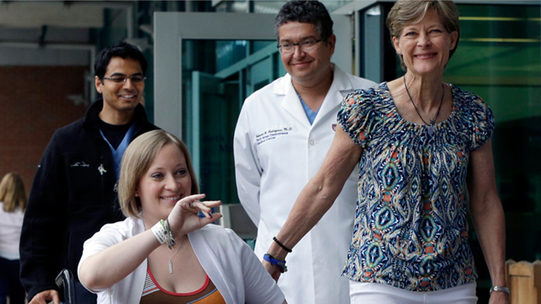 June 3, 2013: Boston Marathon bombing survivor Erika Brannock, 29, is accompanied by her mother, Carol Downing, right, as she is released from Beth Israel Deaconess Medical Center in Boston.