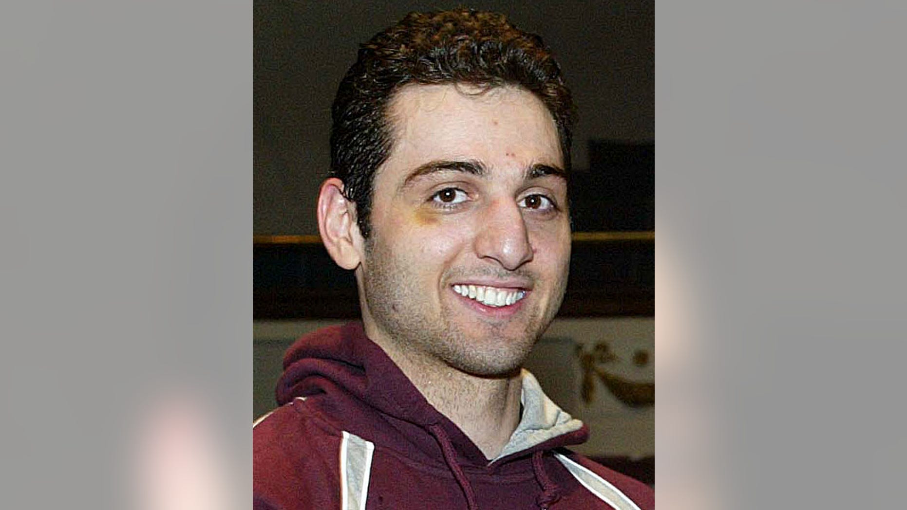 In this Feb. 17, 2010, photo, Tamerlan Tsarnaev, smiles after accepting the trophy for winning the 2010 New England Golden Gloves Championship from Dr. Joseph Downes, right, in Lowell, Mass.