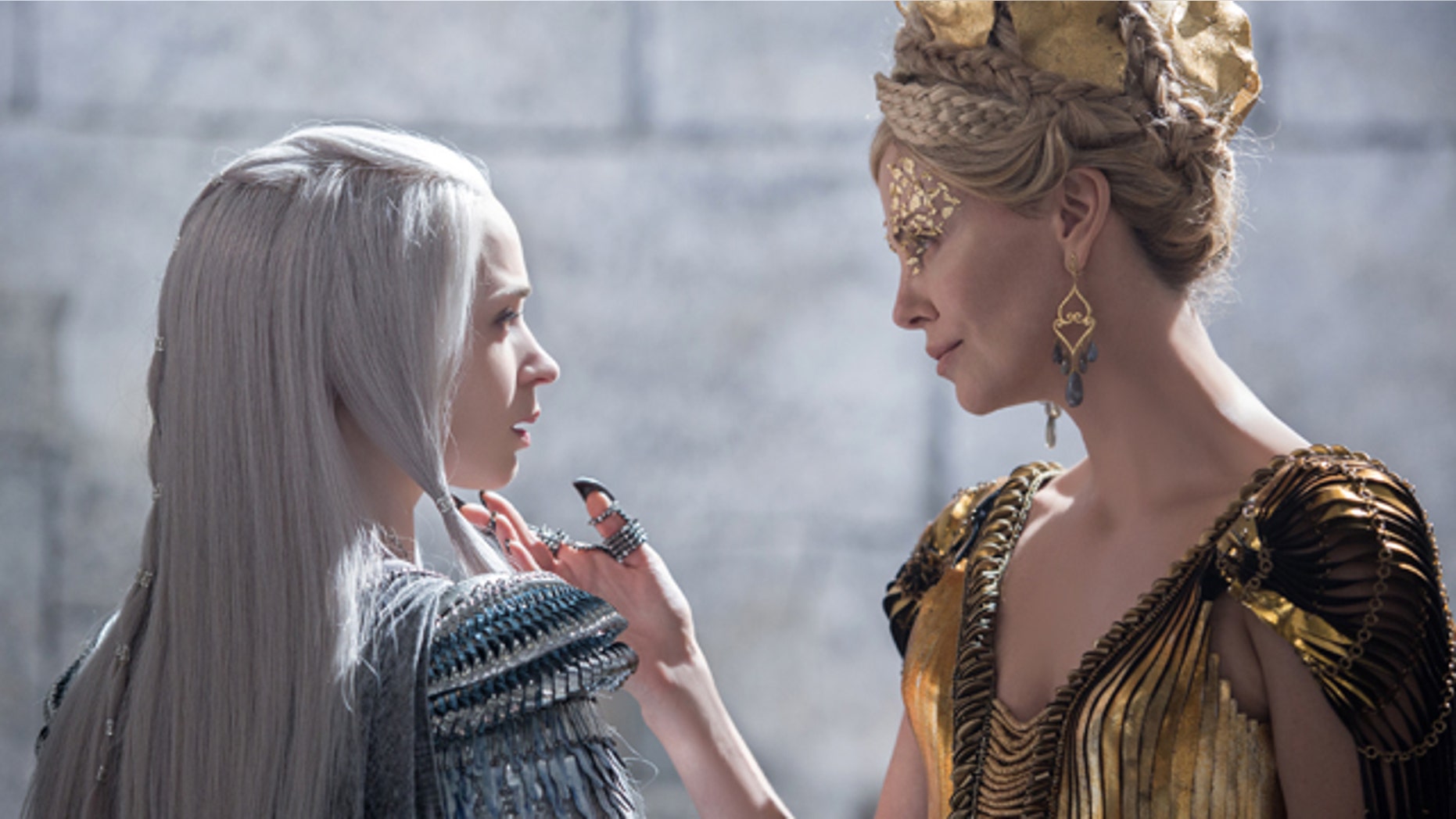 In this image released by Universal Pictures, Emily Blunt, left and Charlize Theron appear in a scene from 'Huntsman: Winter's War.' (Giles Keyte/Universal Pictures via AP)