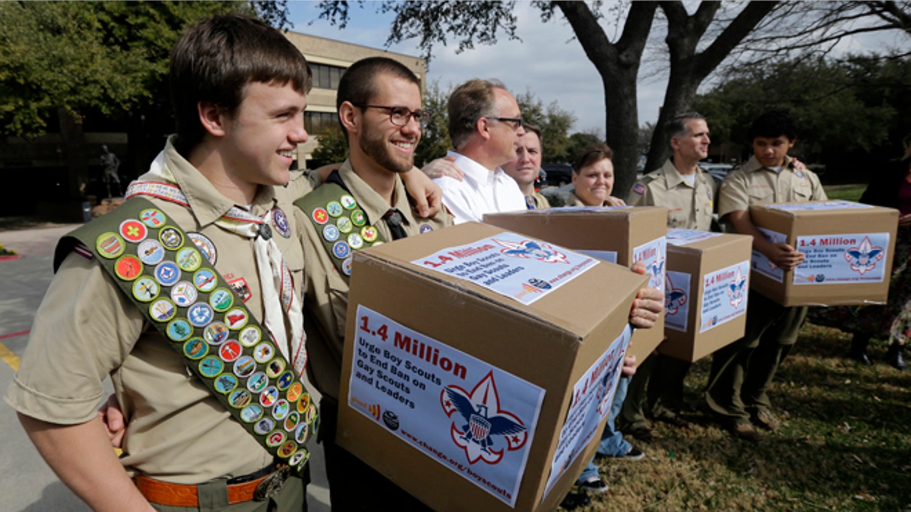 Feb. 4, 2013: In this file photo, James Oliver, left, hugs his brother and fellow Eagle Scout, Will Oliver, who is gay, as Will and other supporters carry four boxes filled with a petition to end the ban on gay scouts and leaders in front of the Boy Scouts of America headquarters in Dallas, Texas.