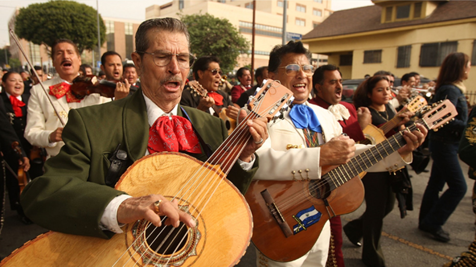 LOS ANGELES, CA - NOVEMBER 25: Mariachis play as they march down a street during the annual procession and Mass in honor of the Feast Day of St. Cecilia, patron saint of music, on November 25, 2008 in the Boyle Heights neighborhood of Los Angeles, California. The procession takes place near Mariachi Plaza where Mexican musicians wait curb-side for customers to hire them. Mariachi, the best-known form of traditional Mexican music, is believed to have started in the nineteenth century in the Mexican state of Jalisco, supposedly in the town of Cocula. (Photo by David McNew/Getty Images)