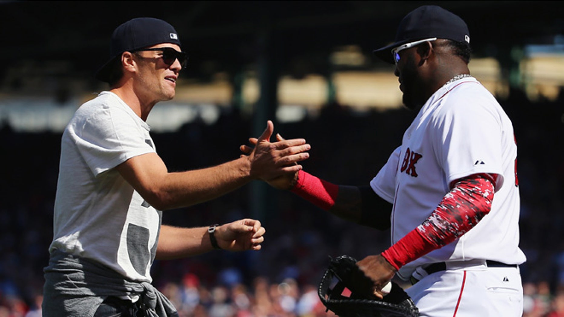 BOSTON, MA - APRIL 13: New England Patriots quarterback Tom Brady talks with David Ortiz #34 of the Boston Red Sox after throwing out the first pitch before the game against the Washington Nationals at Fenway Park on April 13, 2015 in Boston, Massachusetts. (Photo by Maddie Meyer/Getty Images)