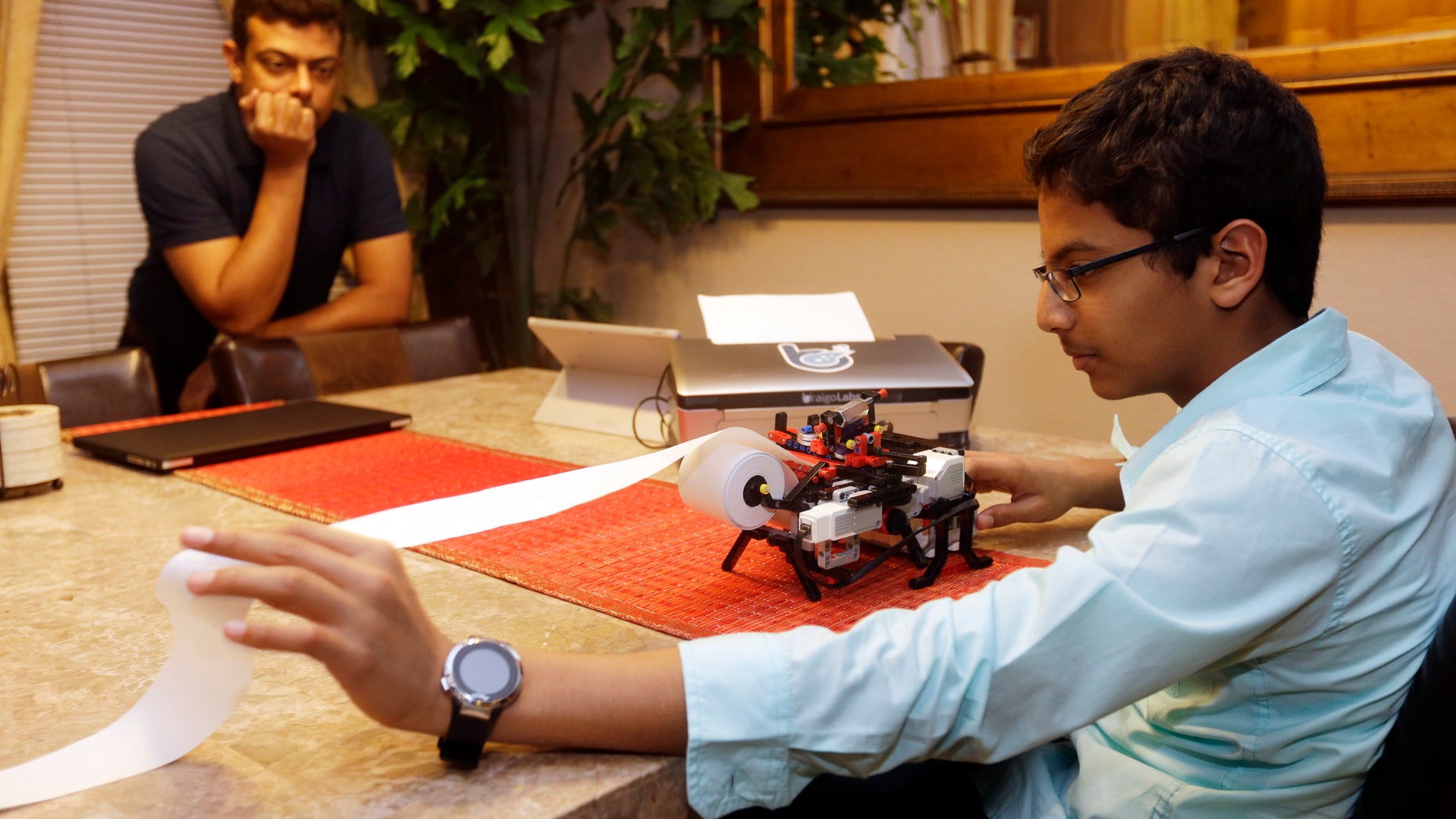 Jan. 6, 2015: Shubham Banerjee, right, world on his Lego robotics braille printer as his dad Neil watches at home in Santa Clara, Calif.